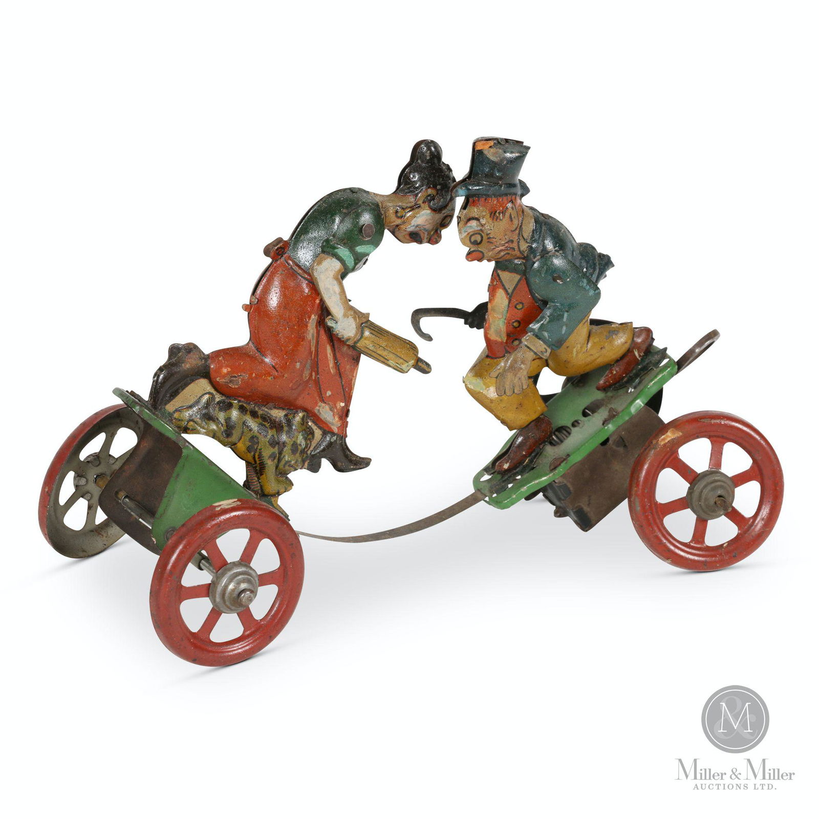 German Maggie & Jiggs Platform Toy: German. 1920s. Lithographed tin. Nifty. Functioning. Marked, "Made in Germany" on the inside of Jiggs' left foot. 7 x 3 x 4.5" (h). Exhibits scattered surface loss with minor touch up.