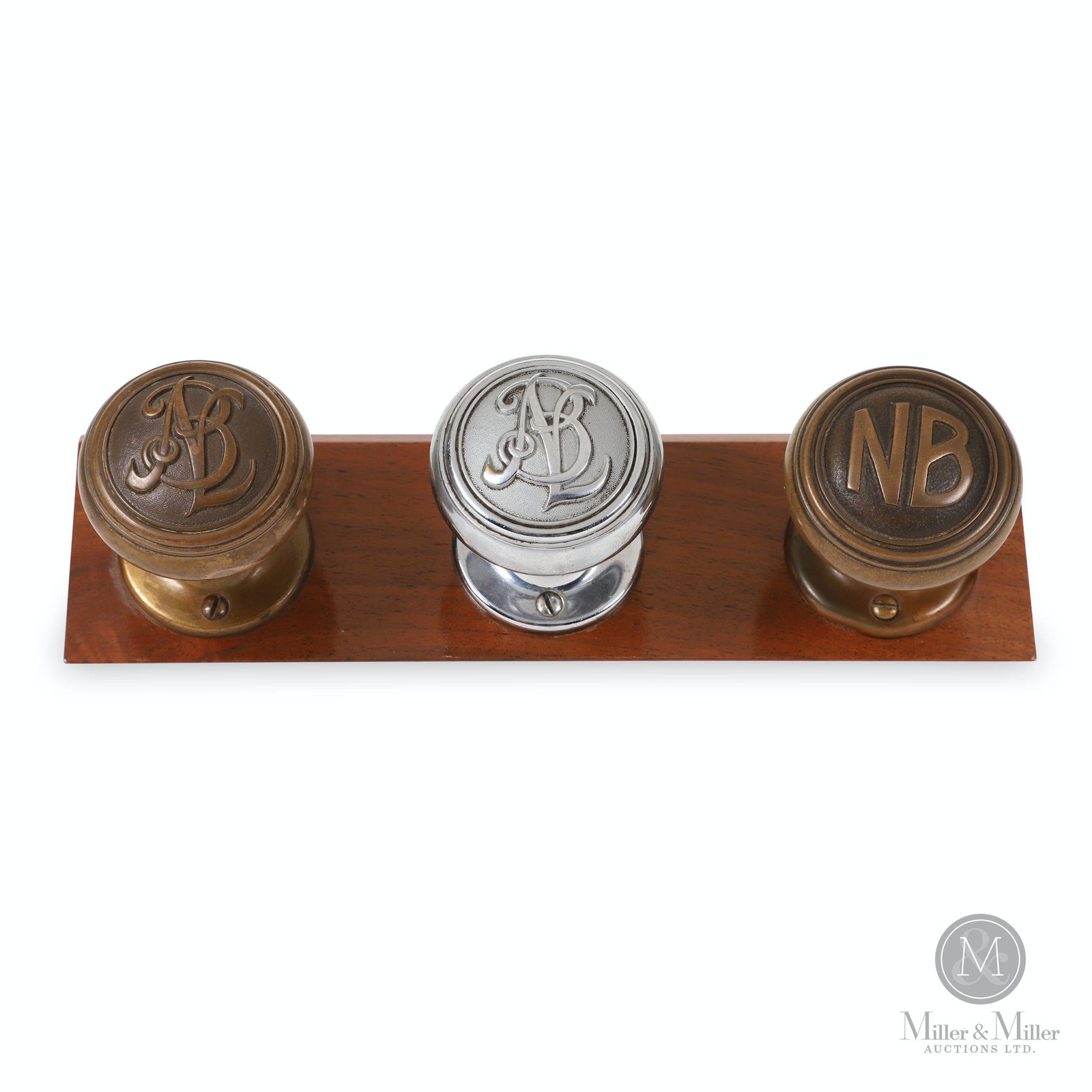 National Breweries Ltd. (Dow) Branded Door Knobs: Canadian. 1920s. Includes two solid brass and one nickel plated brass examples. Mounted to walnut display stand. Each stamped with NBL or NB for National Breweries Limited. 2 1/2" (diam) each.