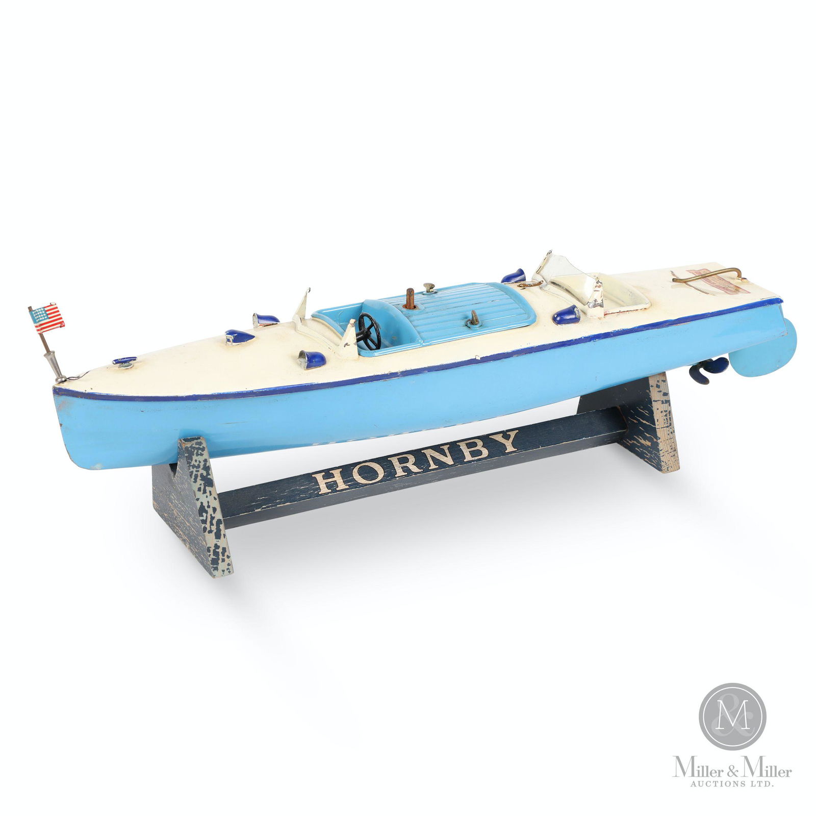 Meccano Hornby Speedboat #3 'Racer' Toy: English. 1930s. Pressed steel. Clockwork motor. Includes original branded Hornby boat display stand. Decalled, "Hornby Speedboat - Manufactured by Meccano Ltd., Liverpool, England". 16 x 3.5 x 3". Mec