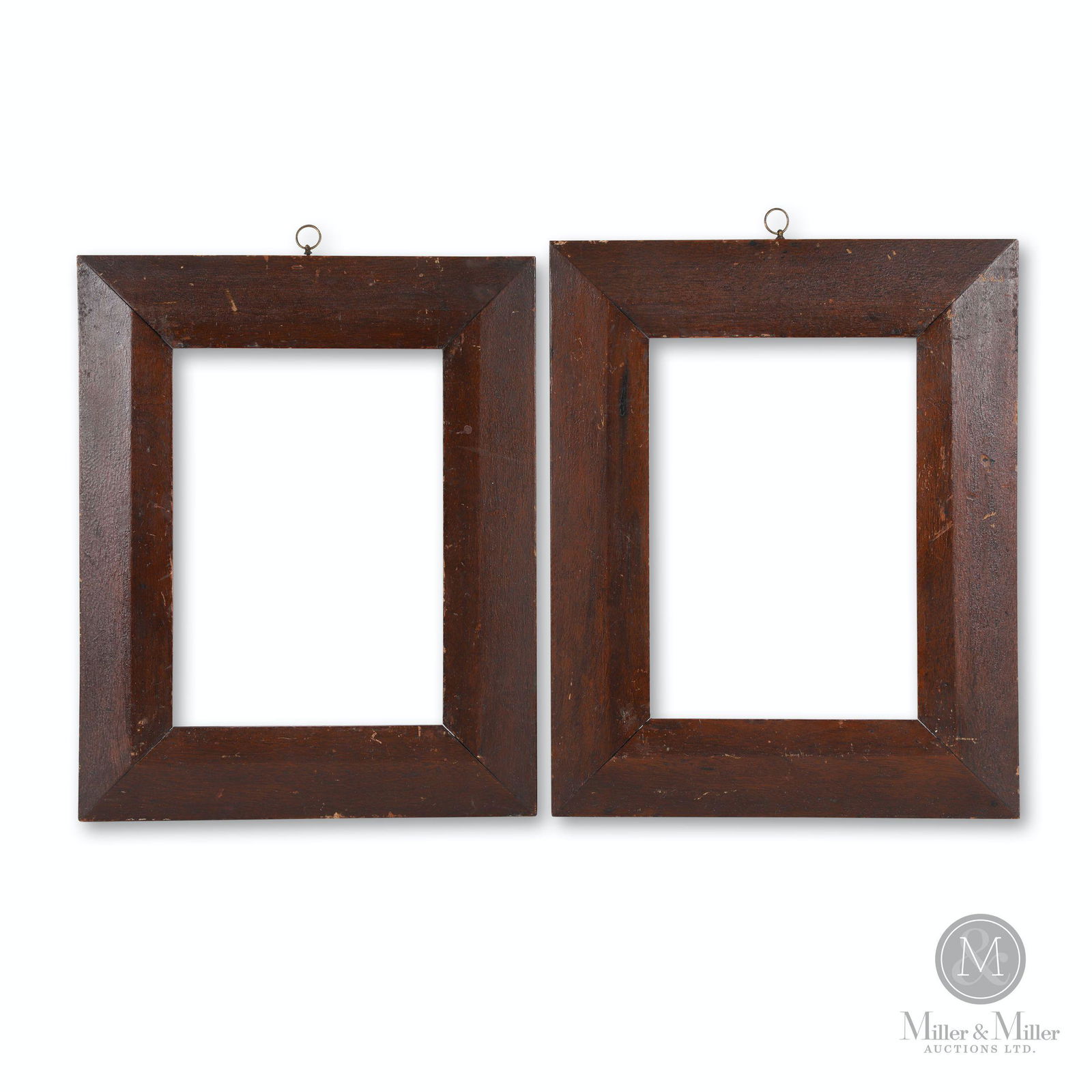 Early Pair of Frames: A pair of beveled edge walnut picture frames in old painted surface with original brass hanging rings. Note the splined mitred corners. Ontario, circa 1840. H: 20.25", W: 16.25"; Sight: H: 13.25", W: