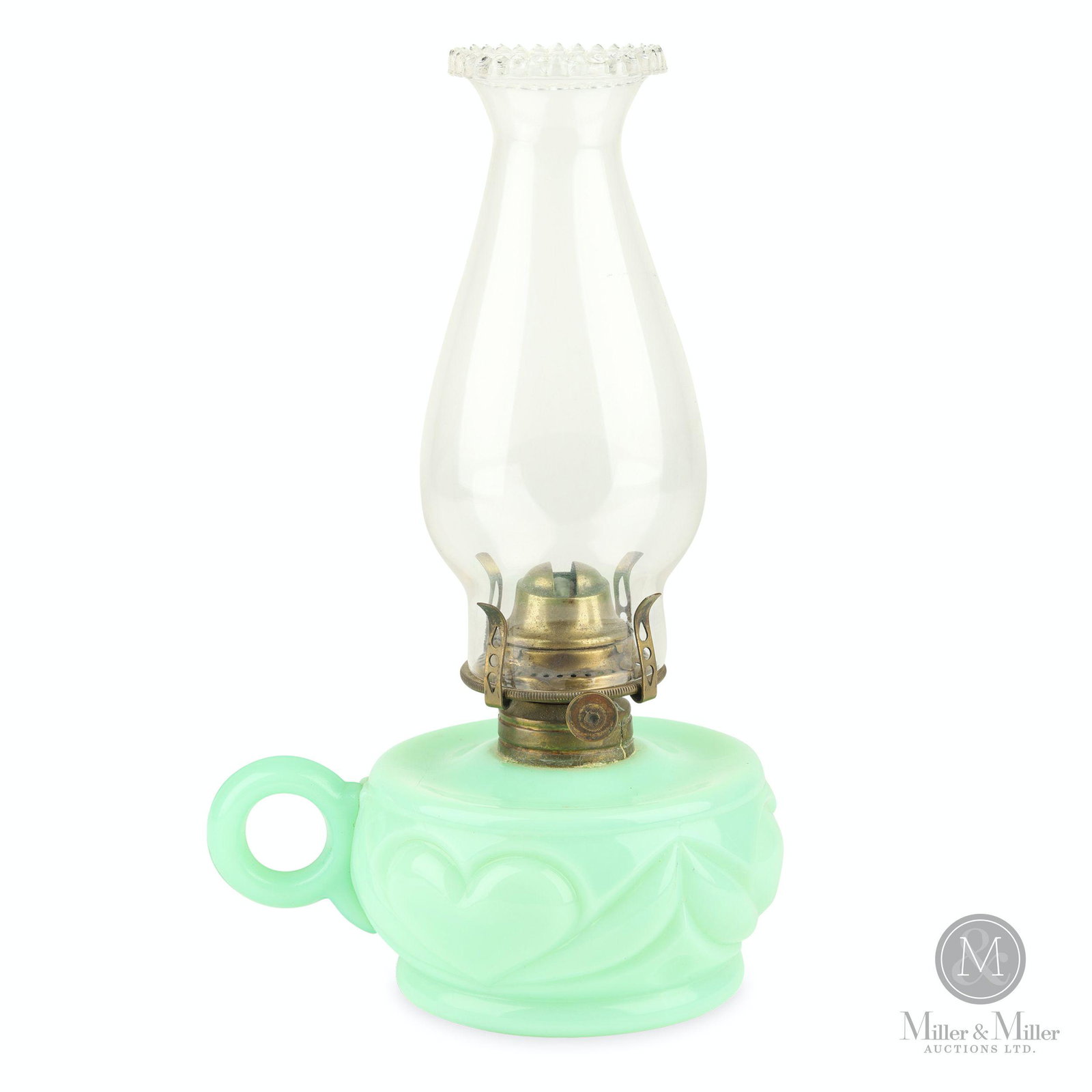 Custard Heart Pattern Finger Oil Lamp: American. 1890s. Custard glass with brass collar and burner and clear glass chimney. Features three heavily embossed hearts surrounding the outside of the font. Pie crust chimney. 3 x 6 x 4 1/2". Exhi