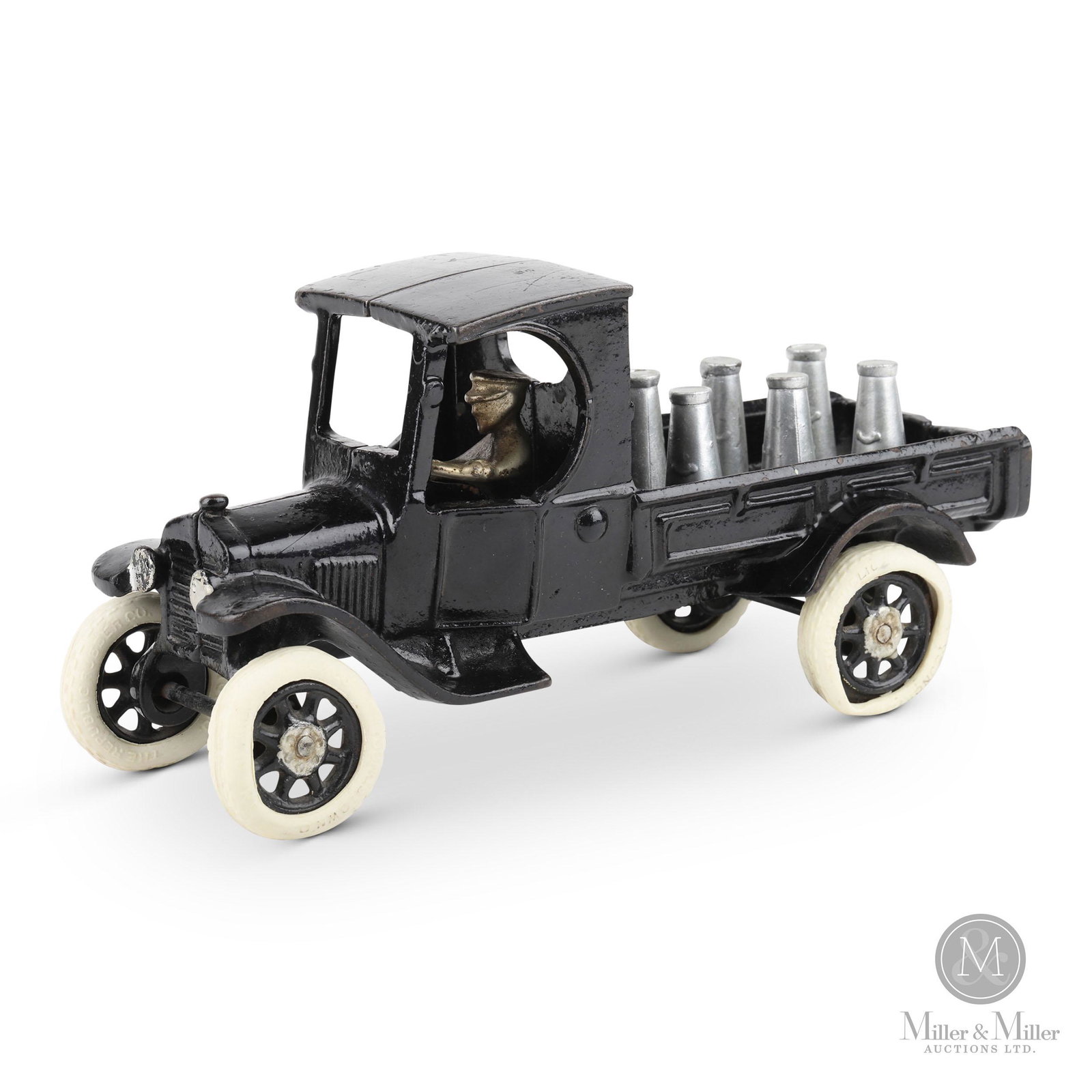 Arcade, Cast Iron S2 Milk Truck: Toy is complete with driver and six milk cans. From the Tanenbaum Collection. Painted cast iron. Marked "ARCADE". Rubber tires are misshapen, loose and have hardened. Scattered areas of light surface 