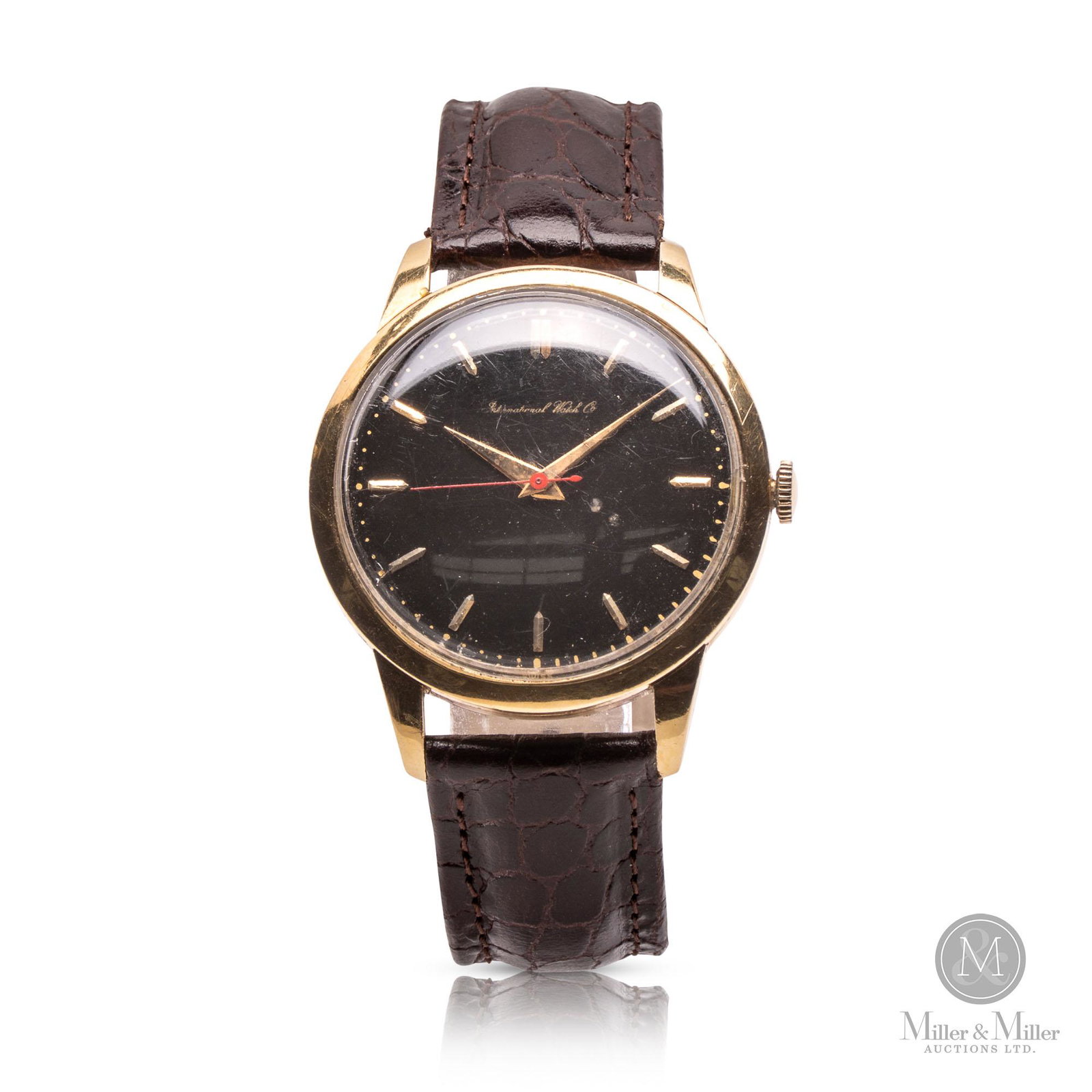 International Watch Co, 18K Dress: Swiss. 36mm case diameter. Circa 1960. Features a simplistic mid-century design with a classy black dial and dauphine hands. 18K gold case. Leather strap. The watch was found to be running at the time