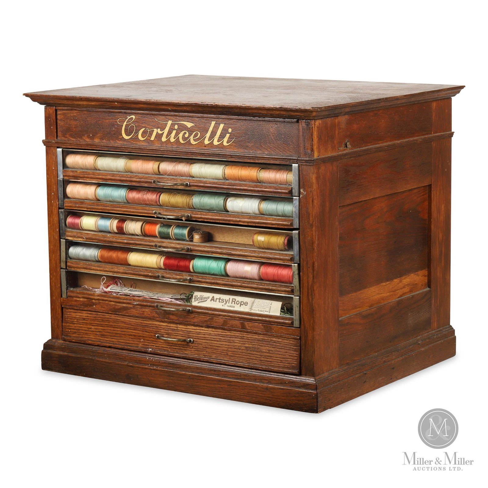 Corticelli Spool Cotton Cabinet: American. 1890s. Oak with glass drawer fronts. Case has received minor restoration including surface finishing. Features plate glass drawer fronts for product visibility. Includes a variety of spool c