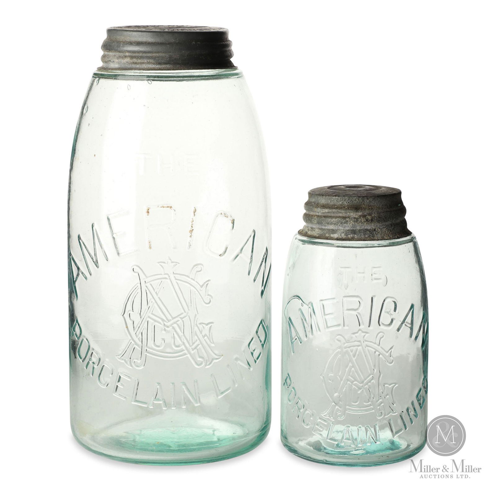 American Porcelain Lined Fruit Jars: Two (2). 1/2 Gallon & pint sizes. American. 1900s. Each jar is light aqua in colour and fitted with correct porcelain lined zinc lids. One cap marked, "Genuine Boyd Cap for Mason Jars". 5.75 and 9.25"