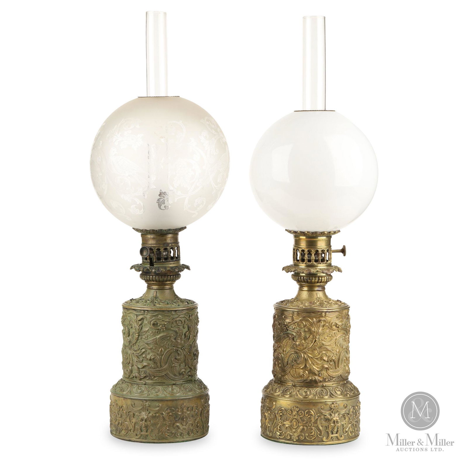Carcel Mechanical Oil Lamps: Two (2). European. 1800-1830. Metal, glass. Cylindrical metal fonts, decorated with scrolls, birds, flowers, berries, acorns and faces. One lamp has an etched ball shade, the other with a white shade.