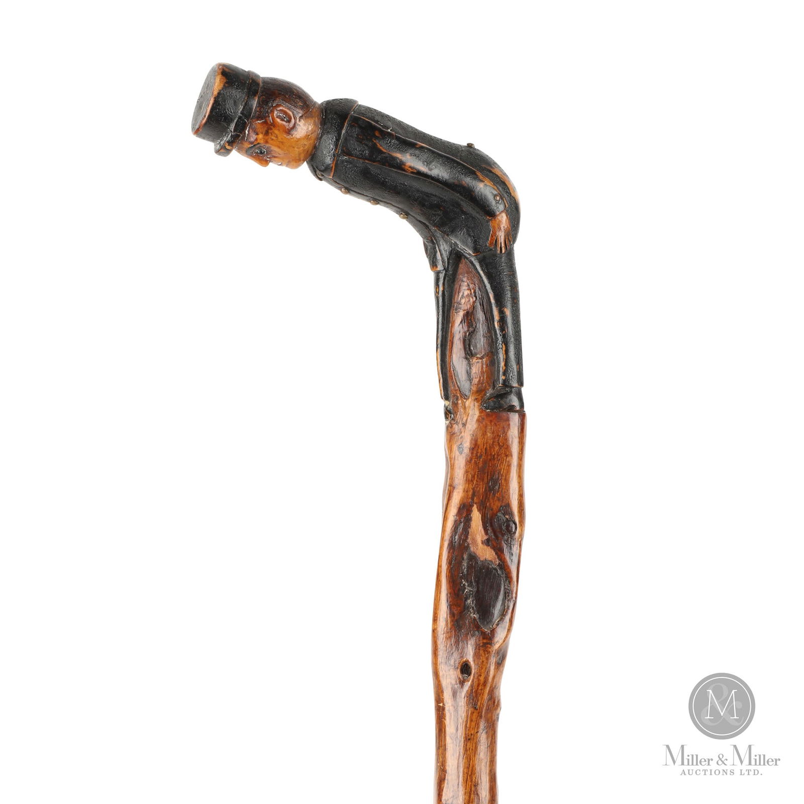 Excellent Continental Walking Stick: Continental. Hardwood. An excellent continental walking stick having a finely carved figure of a train conductor for the handle atop a simple varnished shaft. The figure is in a black uniform with whi