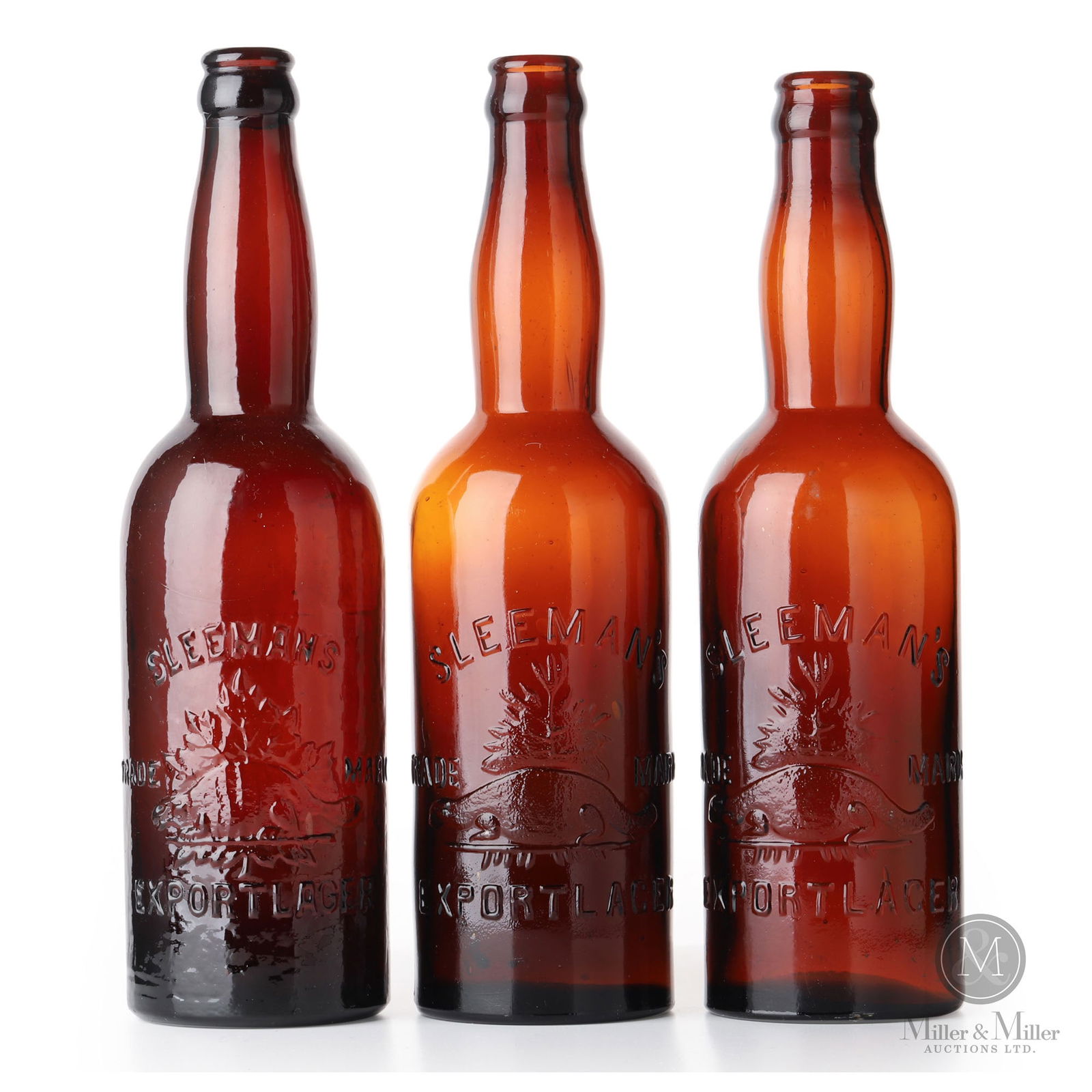 Sleeman Brewery Guelph, Ontario Beer Bottles: Canadian. 1910s. Glass. One of the bottles is heavily whittled. 10" x 2.75" x 2.75" each. From the William Robert Wilson Collection.