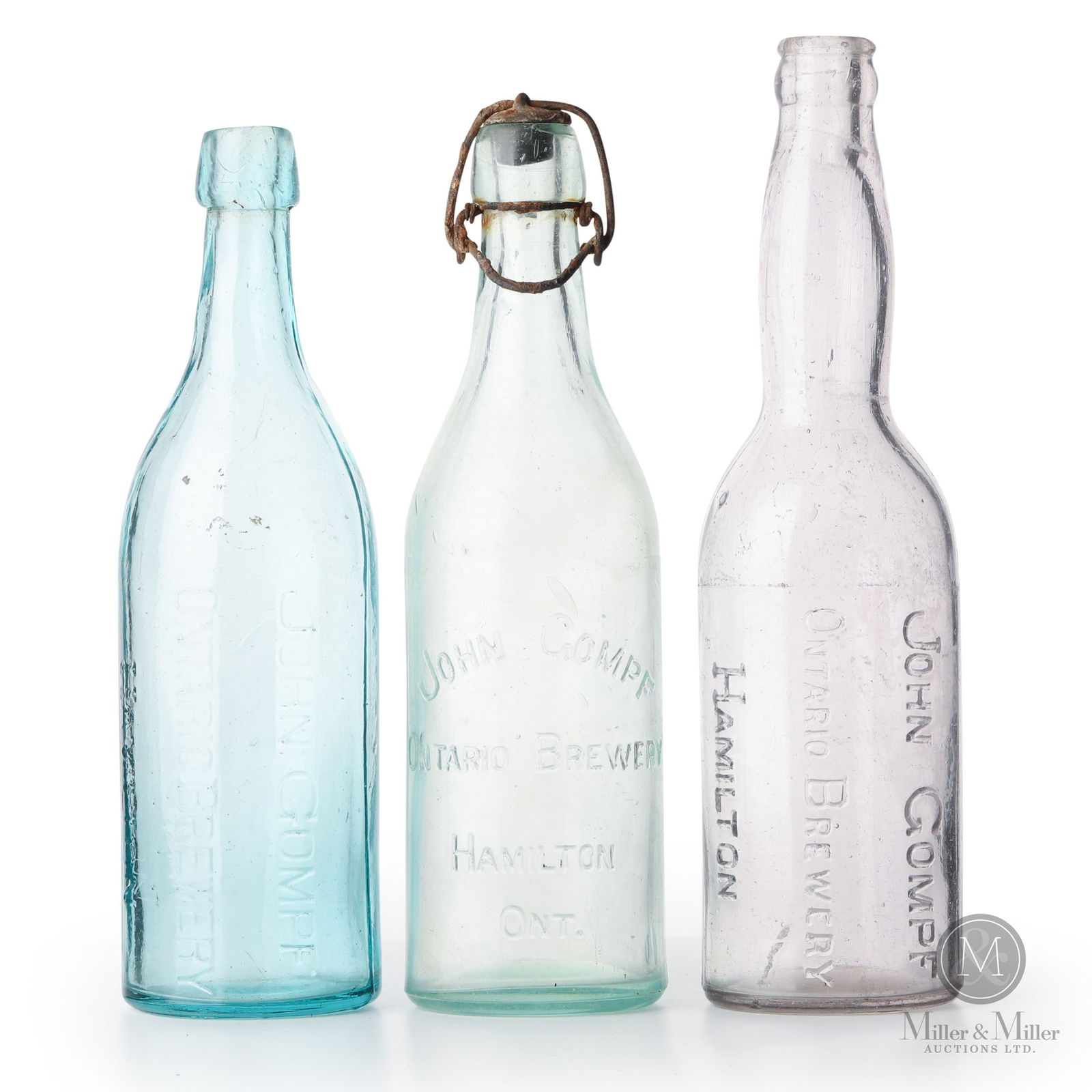 John Gompf Brewery Hamilton, Ontario Beer Bottles: Canadian. 1890s-1910s. Glass. 9.75" x 2.75" x 2.75", 9.75" x 2.75" x 2.75", and 10.5" x 2.75" x 2.75". From the William Robert Wilson Collection.