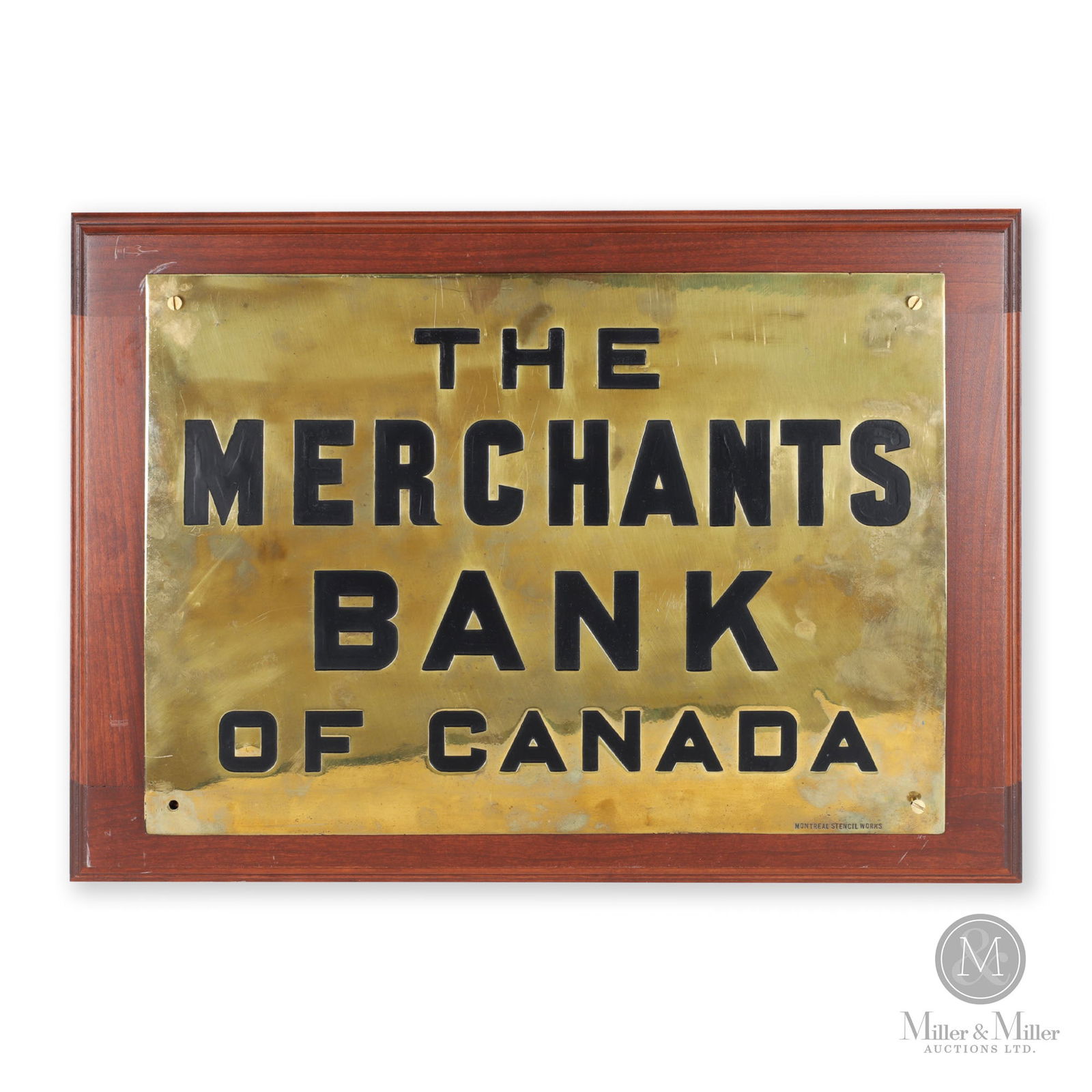 Merchants Bank of Canada Building Plaque: Canadian. 1910s. Stamped brass with enamelled letters mounted to wood frame. Marked, "Montreal Stencil Works", bottom right edge, Brass sign: 14" x 20" x 0.12". From the William Robert Wilson Collecti