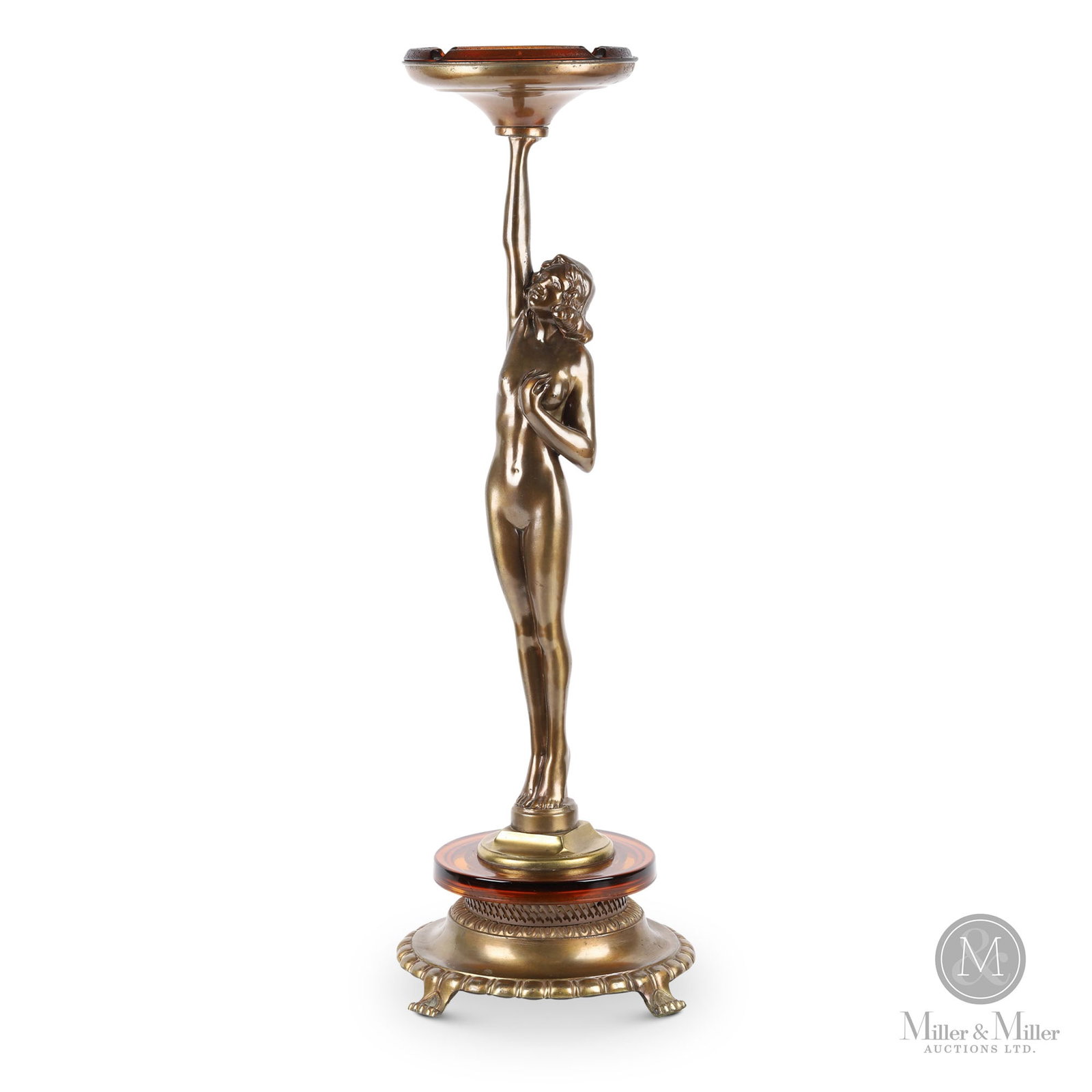 Spelter Art Deco Nude Ashtray: 1920s. Glass. Brass and copper finish on cast metal. Figural female Art Deco ashtray features amber textured glass ashtray insert on a brass & copper finish cast metal stand. 32.25" x 11" x 11".