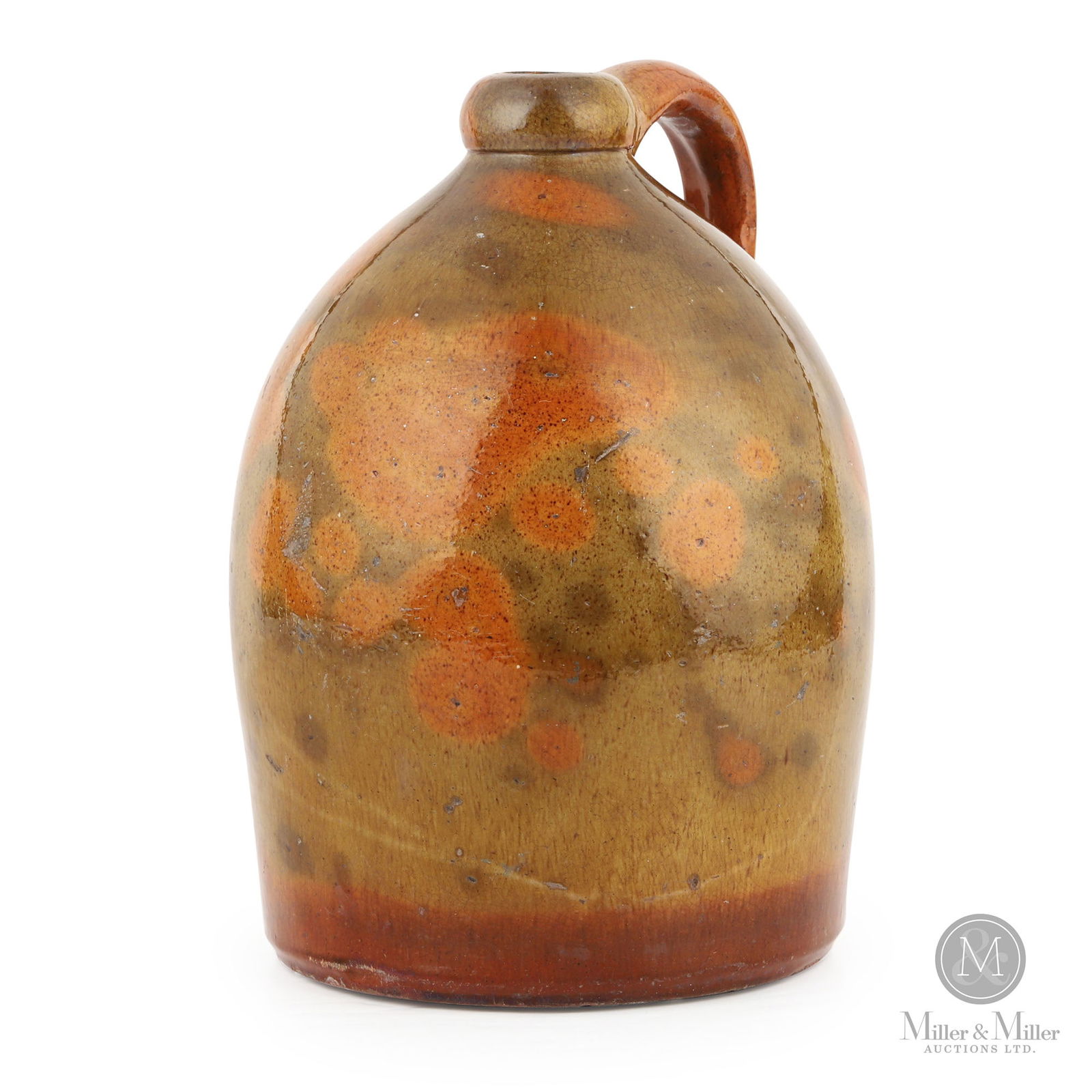 Ontario 1-Gallon Redware Jug With Mottled Green/Orange Glaze: Ontario. 1860s-1870s. Earthenware. Very appealing mottled glaze on this jug. Its features, particularly the rounded spout, suggest Ahrens/Paris however other possibilities exist. Ex-Cameron collection