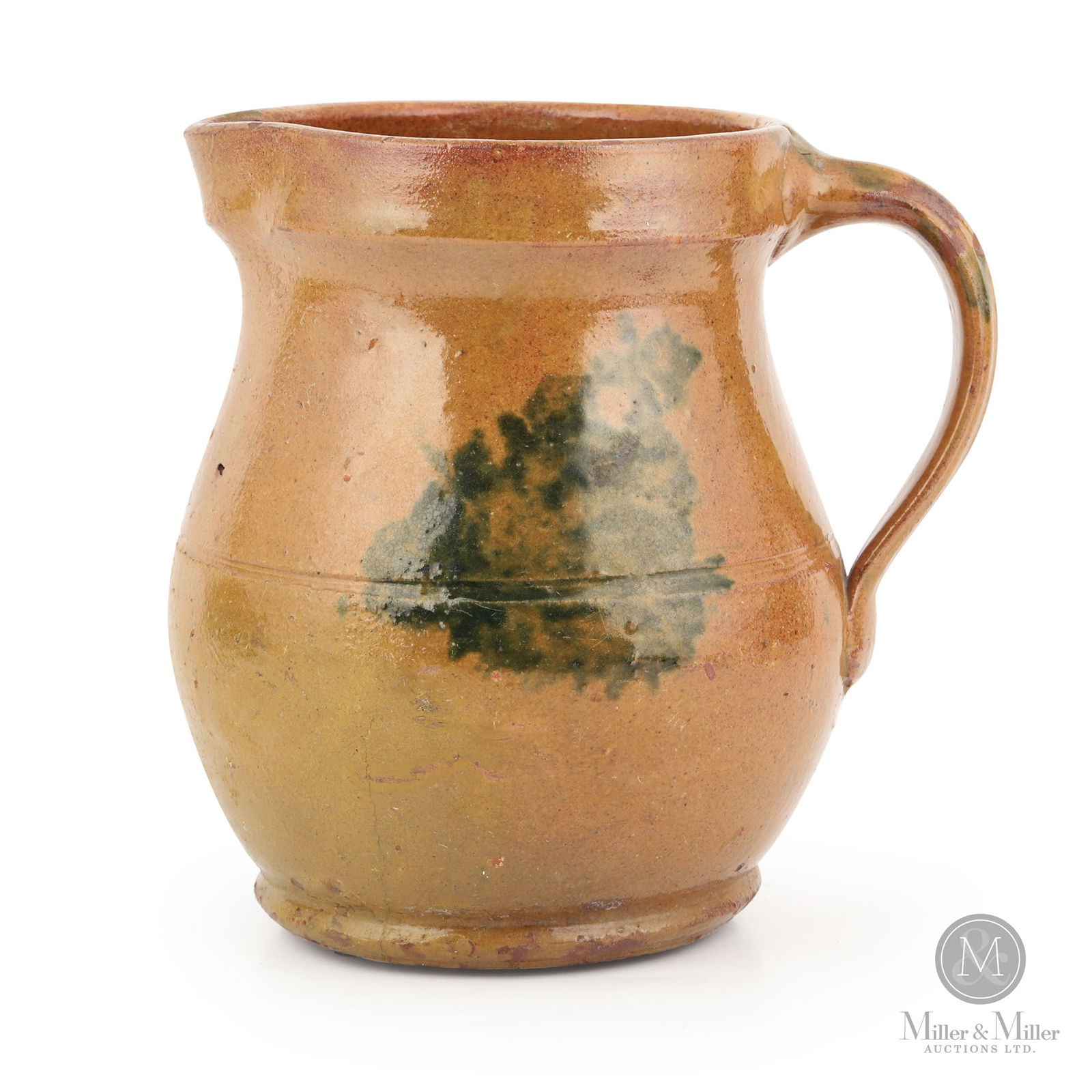 Redware Pitcher With Green Sponged Decoration: Ontario. 1870s-1880s. Earthenware. A small and beautiful redware pitcher with many interesting features including the pronounced rim, ribbed handle and dark green decoration on three sides and the han