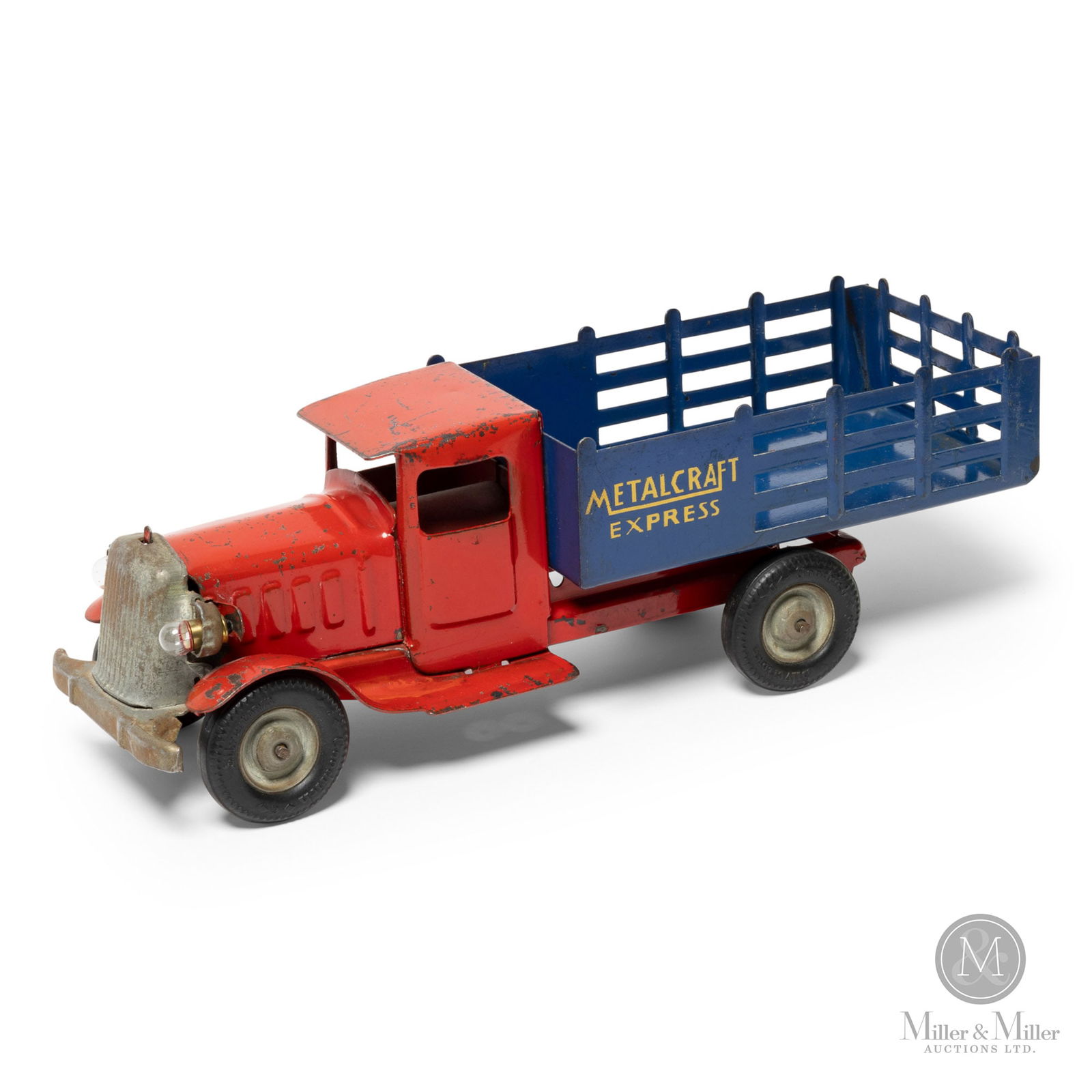 Metalcraft Stake Truck: American. 1930s. Marked, "Metalcraft Corp. St. Louis Made in U.S.A.", on underside. Marked, "Metalcraft", on sides of cargo area. Marked, "Goodrich Silvertown", on tires. Size 12" x 4" x 4". Condition