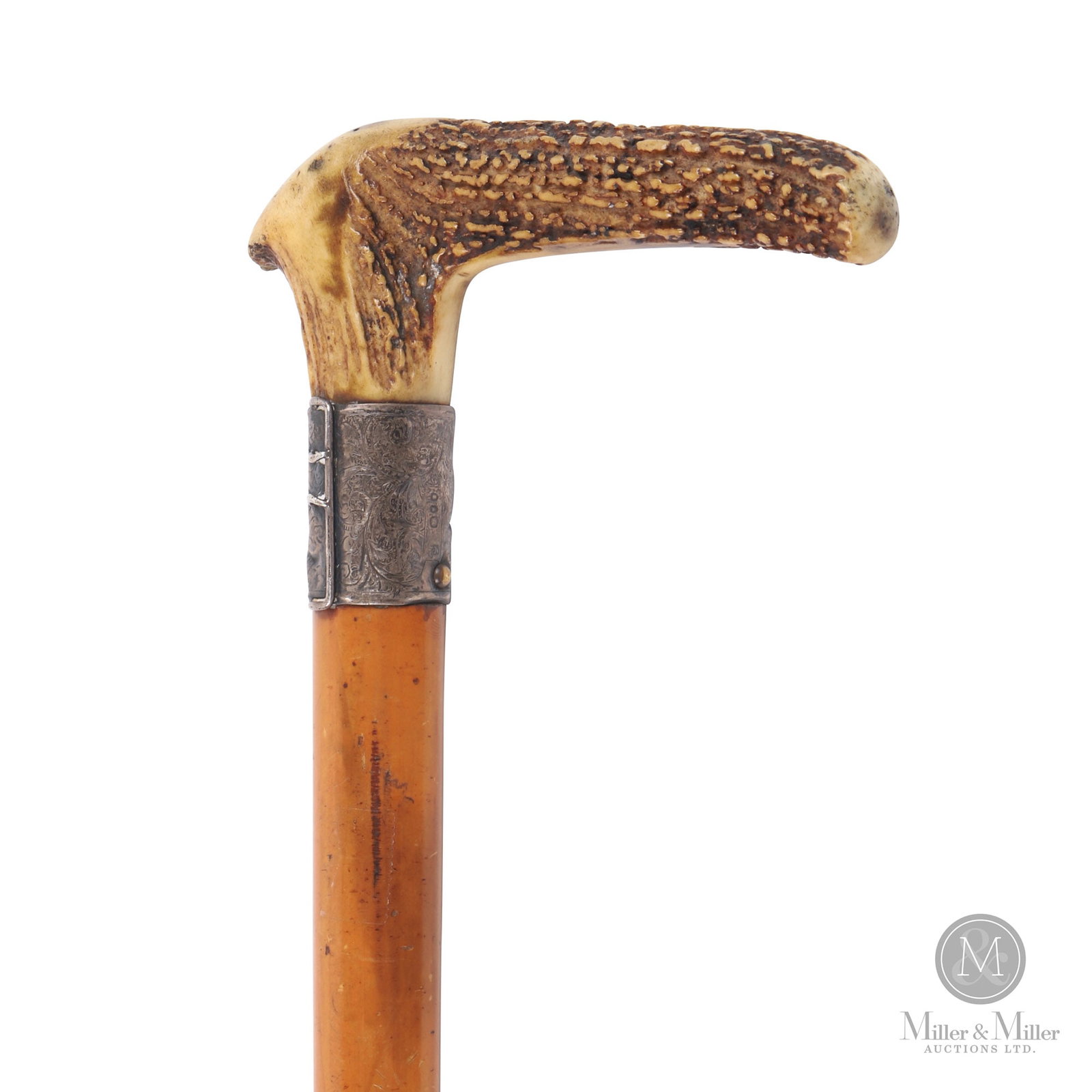 Bone Handled Sword Gadget Walking Stick: American or British. 19th century. Antler, steel, silver. Sword stick with a natural antler for handle, over a silver buckle with engraved design and a stained hardwood shaft. The lower end with a ret