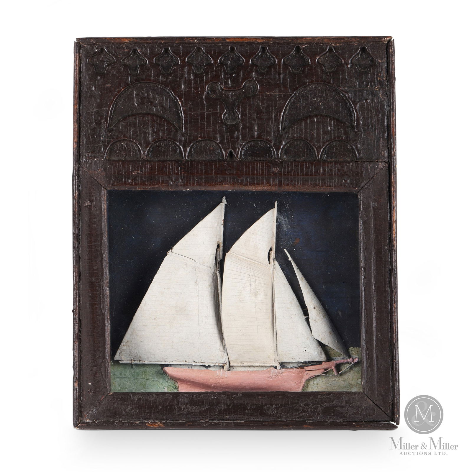 Newfoundland Folk Art Ship Diorama: A unique diorama having a substantial rectangular crest above the framed and glazed box containing a pink hulled schooner with wooden sails. The crest is decorated with recessed half-moons and other m
