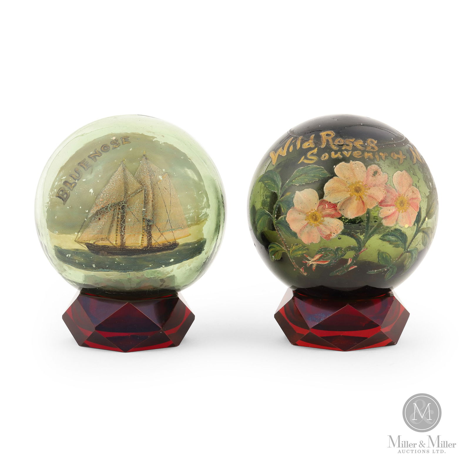Bluenose and Wild Rose Net Floats: A pair of blown glass fishing net floats re-purposed in the 1930s as decorative souvenirs. One is clear glass with a hand-painted image of the Bluenose in full sail and marked "Bluenose August 23, 193