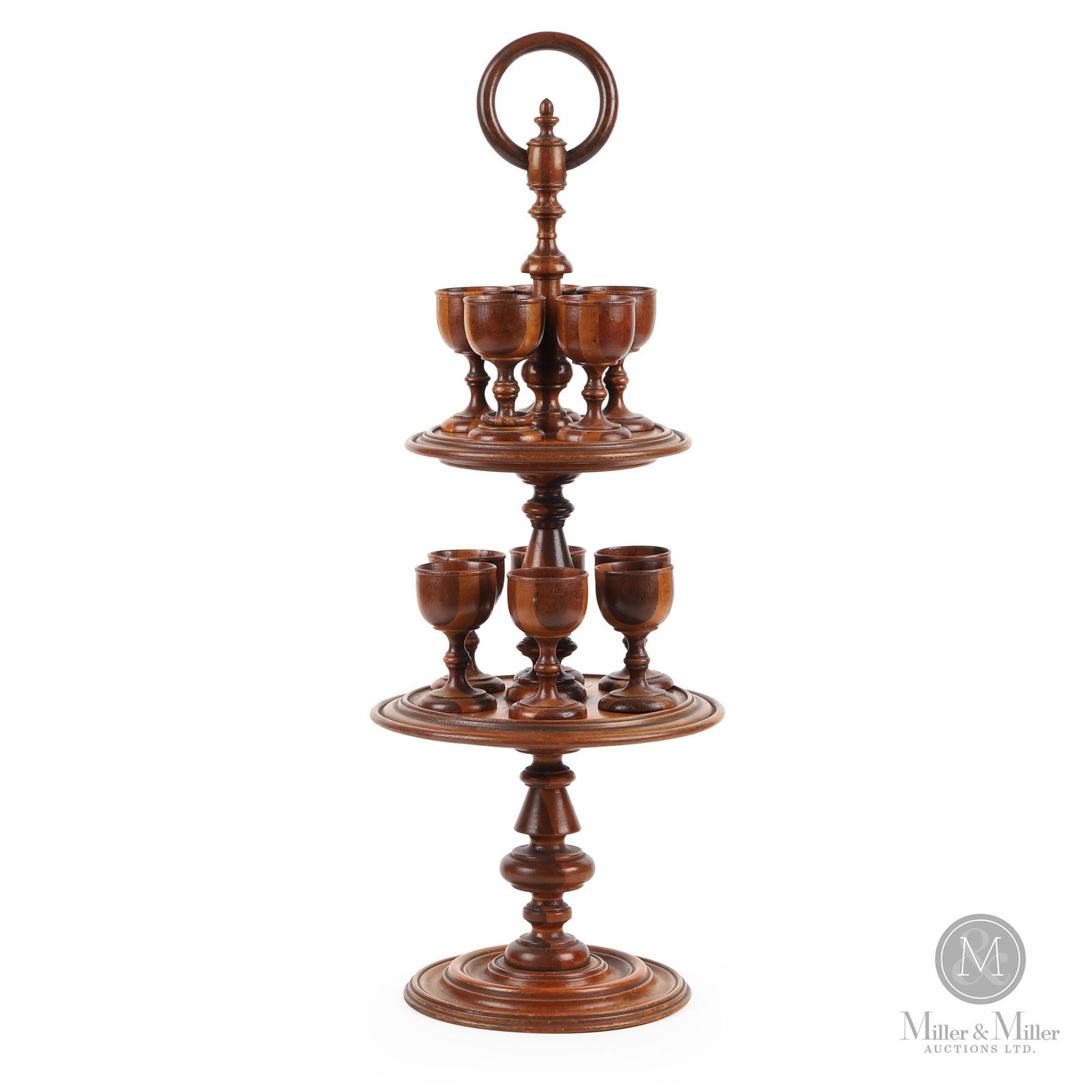 Tiered Egg Cup Stand: A two-tier turned egg cup stand with a wooden ring finial and the central shaft and cups being lathe turned laminated dark and light wood. The round shelves are turned with a well-defined moulded edge