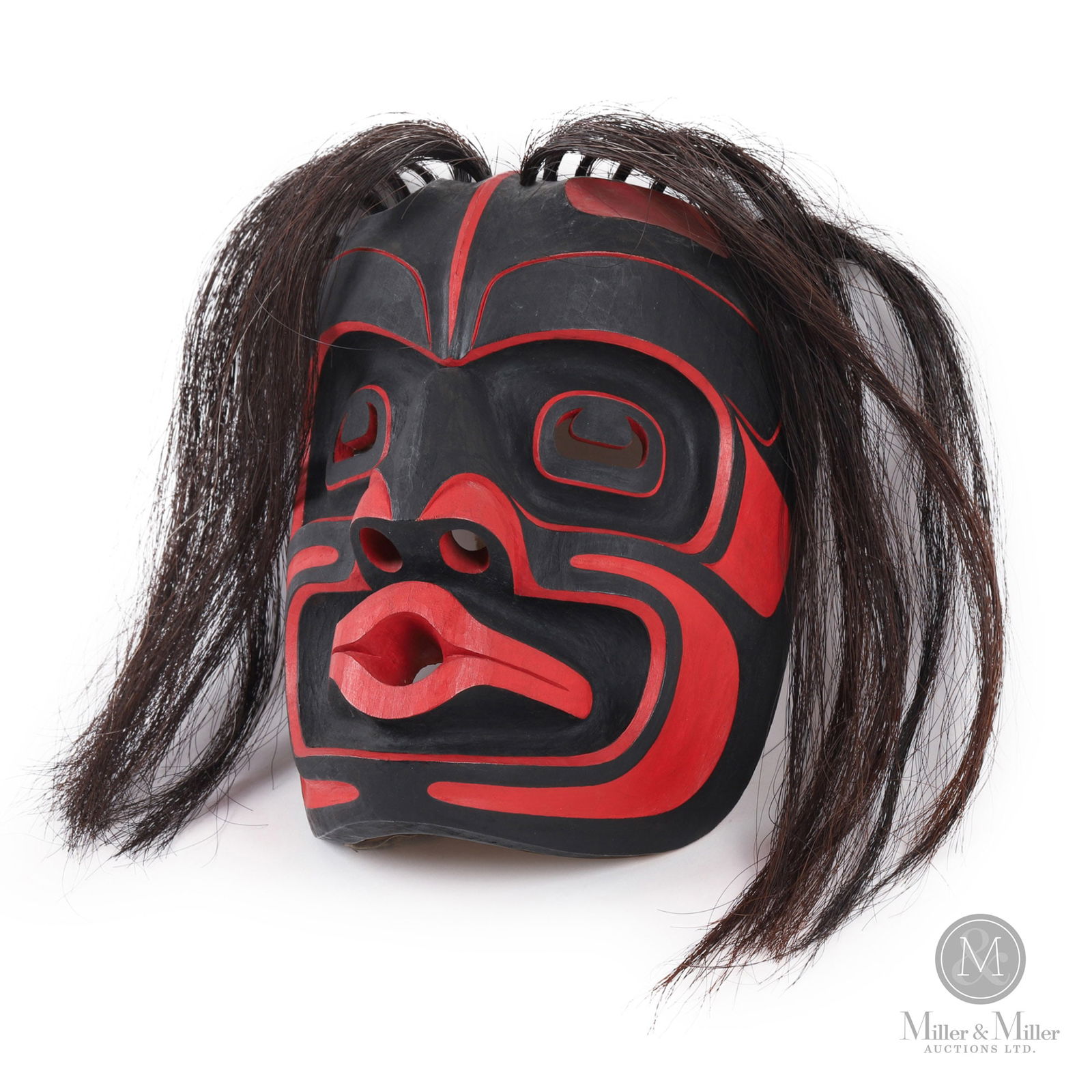 Tony Hunt Jr. "Wild Woman" Mask: A dramatic mask carved by Tony Hunt Jr. titled, "Kwagiulth Wild Woman". Excellent condition in original black and red paint with original head strap. Tony Hunt Jr. is a Kwagiulth artist who comes from