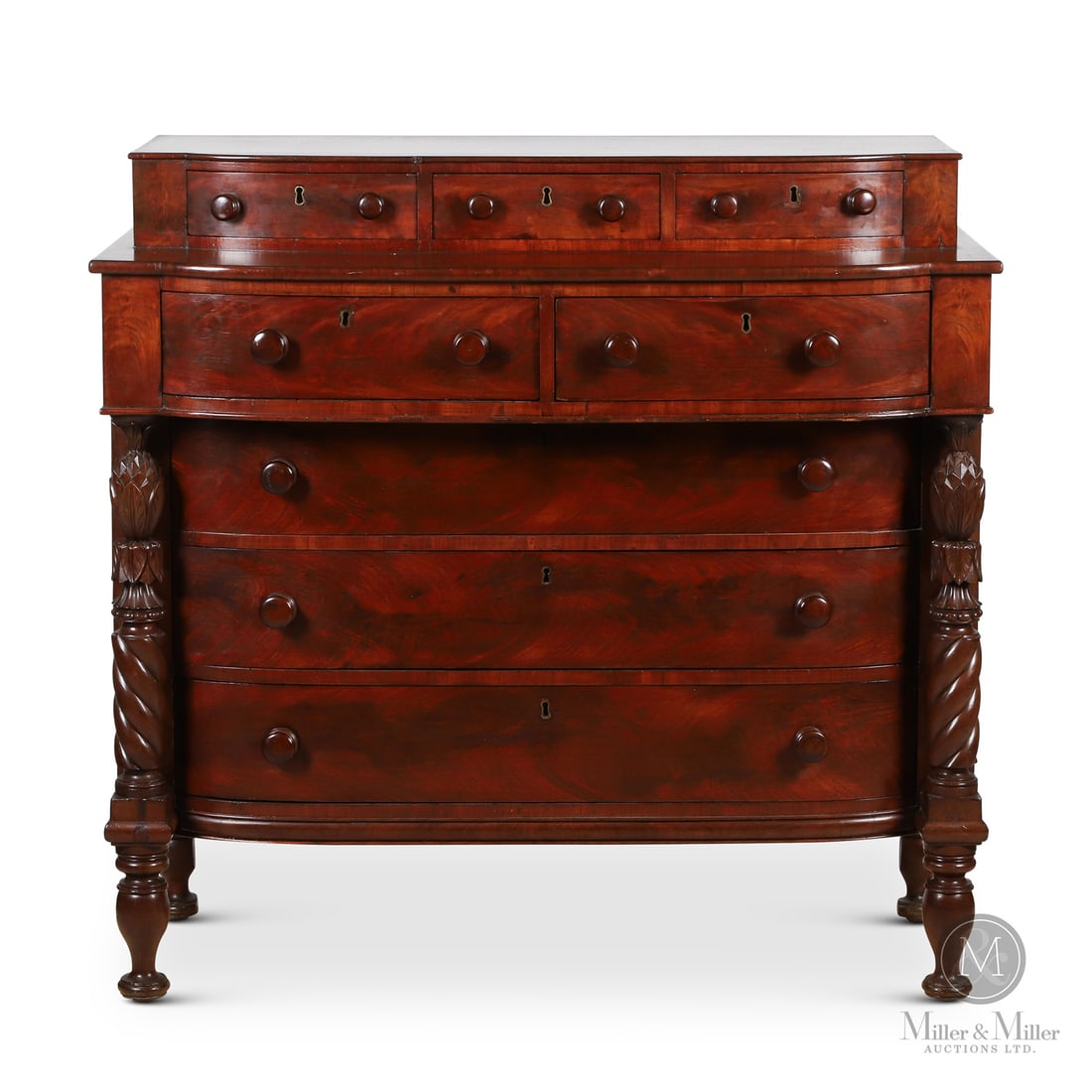 Nisbet Chest of Drawers: Canadian. Wood. A chest of drawers in rich dark mahogany with bowed drawer fronts and attributed to Thomas Nisbet, Saint John, New Brunswick. Carved rope twist columns with pineapple finials flank