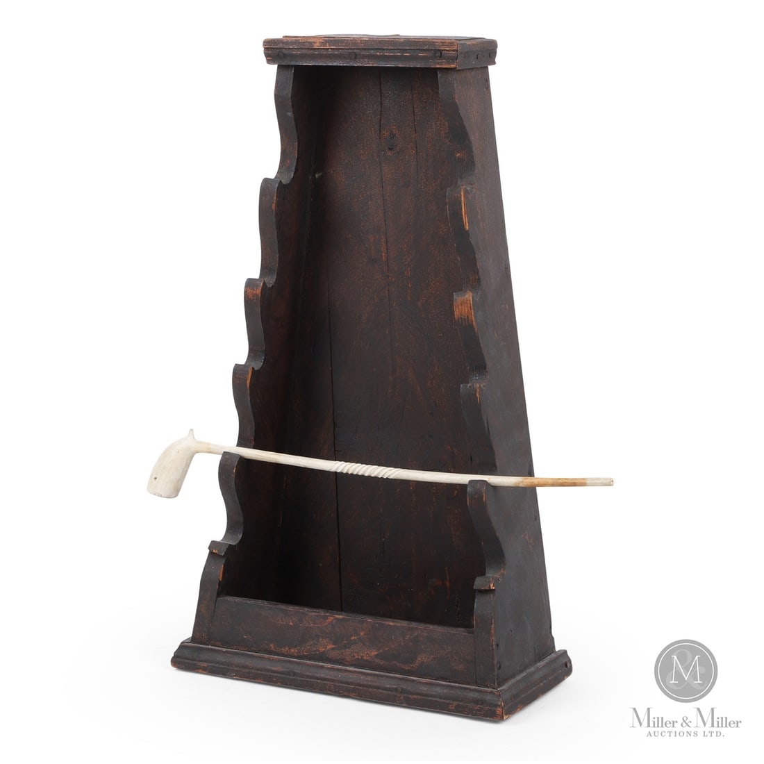 Cape Breton Pipe Box: Canadian. Wood pine. A tiered pine pipe box in original paint, having a tapered back with scrolled supports for multiple pipes. A clay pipe is included. Cape Breton, Nova Scotia, late 19th century.