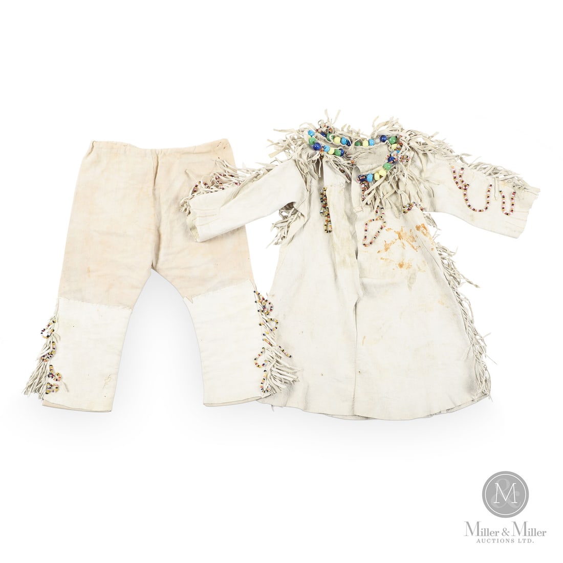 "Native" Christening Dress and Pants: French. Leather. An Indigenous style infant christening robe and pants in fine bleached white Kid leather with glass beads and cut fringe. The pants have leather legs and a linen top with drawstring.