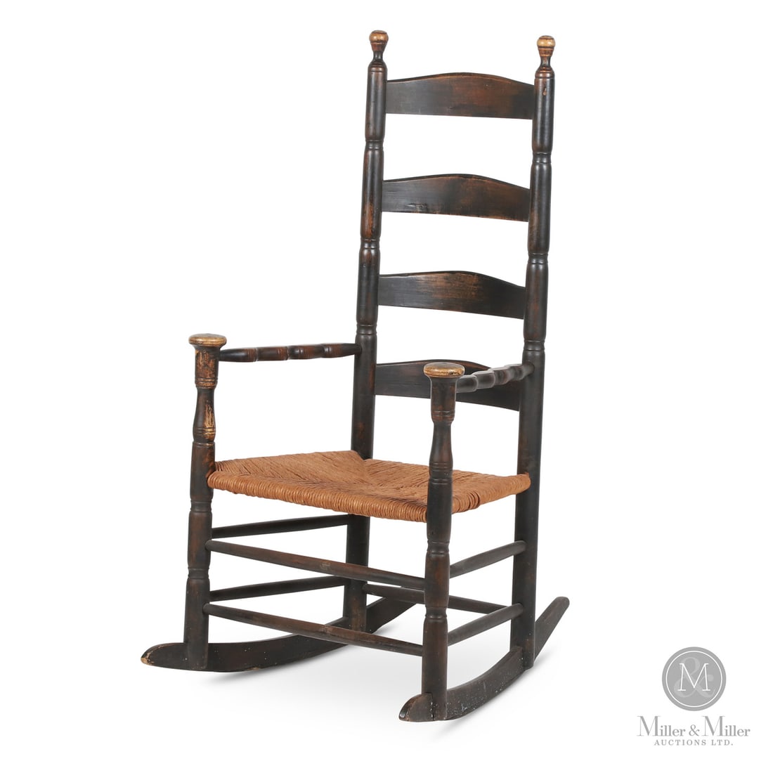 Early Mushroom Arm Rocker: Canadian. Wood. An early slat back rocking chair with split baluster arms and mushroom cap posts. Very good condition with a replaced rush seat, and the rockers have been "rounded out" due to flatteni