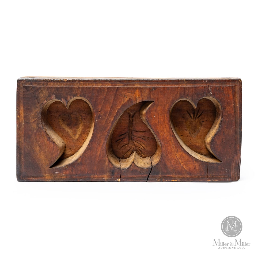 Triple Heart Sugar Mold: Canadian. Wood. A maple sugar mold with three deep hearts, each with an incised motif at the bottom- heart, tree, and sacred heart. Crisp design, good construction, and warm patina. Good condition wit