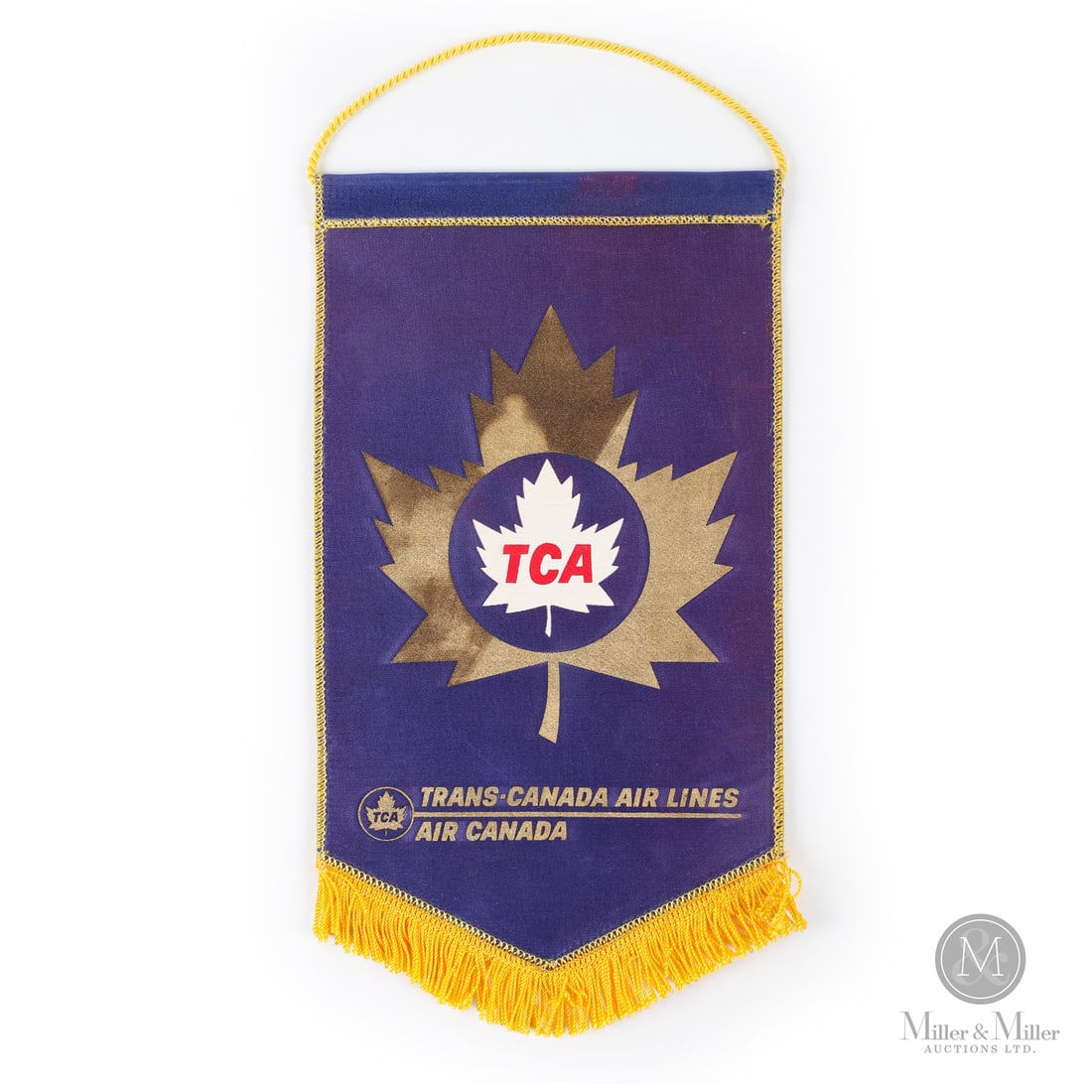 Trans-Canada Airlines Pennant: Canadian. 1960s. Stitched fabric. The banner displays both names ("Trans-Canada Air Lines" and "Air Canada") and uses the older TCA logo (a maple leaf inside a circle). This dual branding was used bri