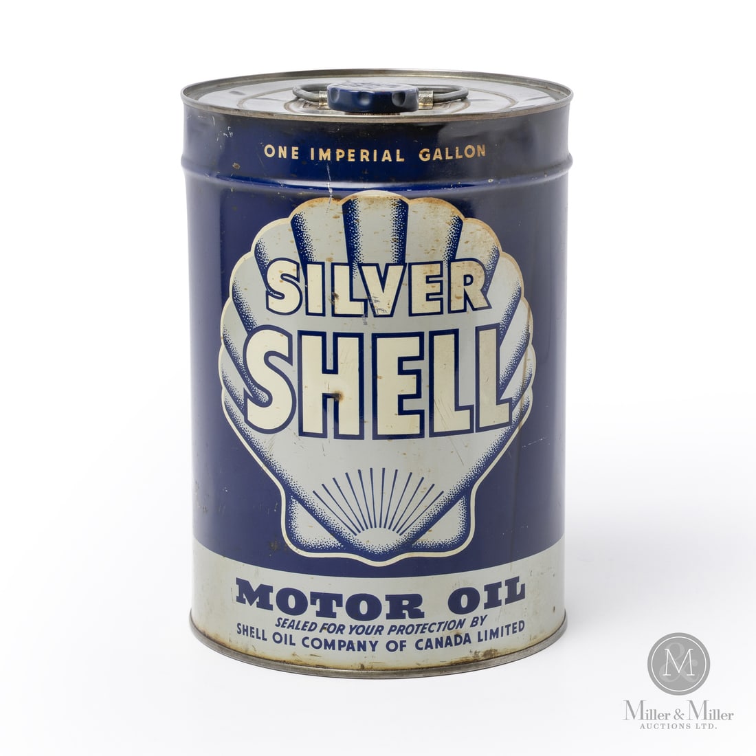 Silver Shell Motor Oil Imperial Gallon Can: Made in Canada. 1929. Lithographed Tin. Introduced alongside Shell Premium, Silver Shell was marketed as their standard or "regular" grade economy gasoline. Marked, "A.C.CO 29AM" lower edge next to se