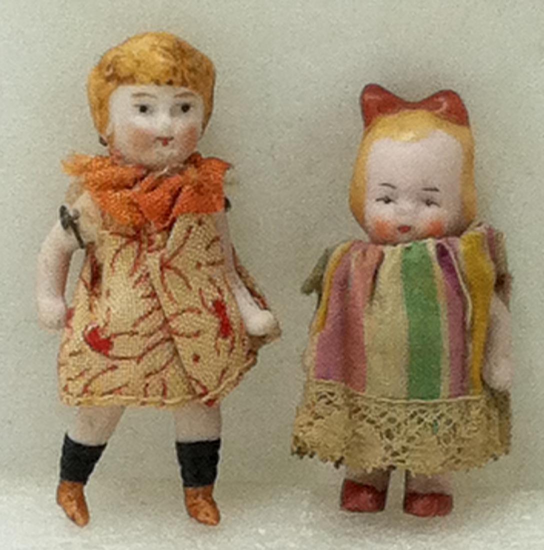 2 Antique Porcelain Mini Dolls: 2 All Porcelain Hand Ptd molded hair girl dolls.1@ 2.25" long has movable arms & legs. Baby @ 2"w/movable arms. Head was glued