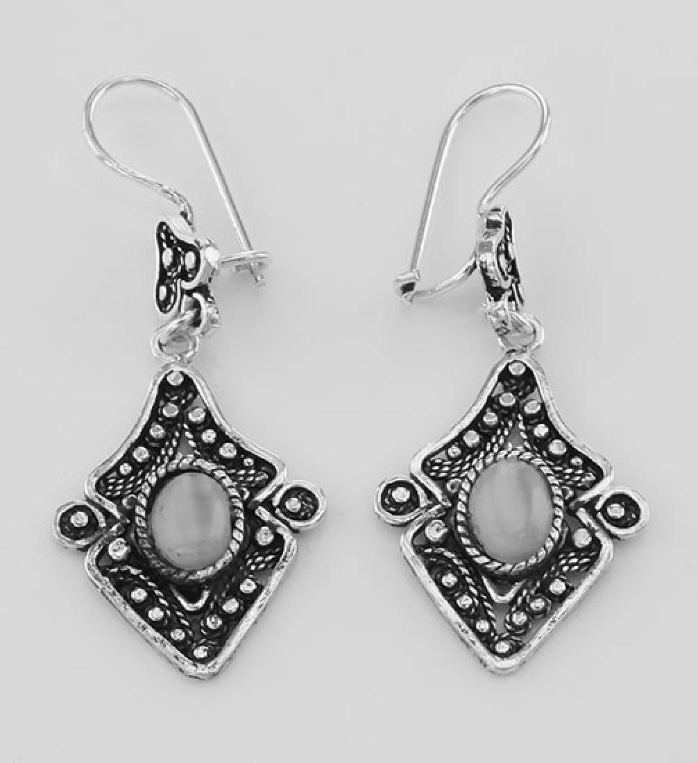 French Wire Moonstone Dangle Earrings - Sterling Silver: French Wire Moonstone Dangle Earrings - Sterling Silver **|**|** #ET-033 Sterling Silver Moonstone / Cat's Eye Dangle Earrings have a hanging length of 2 inches and are 3/4 inches W. The look of the g