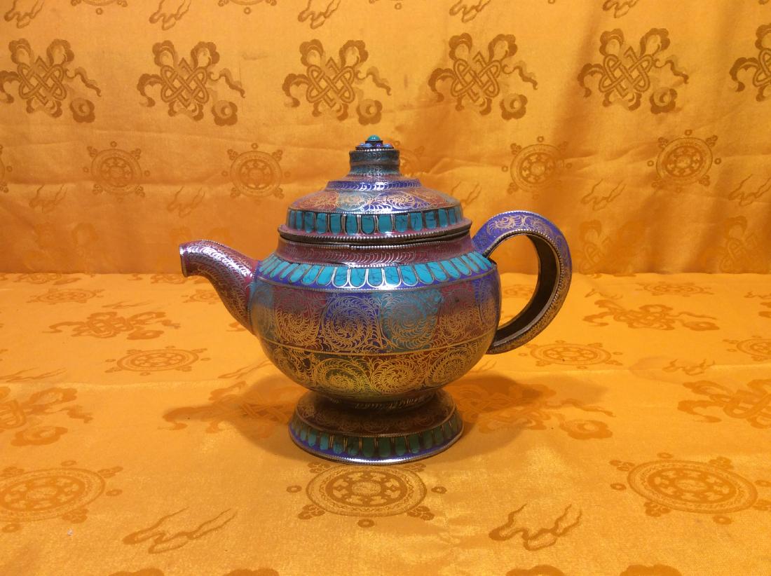 Small Tea Pot.: Small Tibetan Tea Pot hand made in Nepal by Tibetan artists with coin silver filigrated and inlaid turquoise, lapis and coral. Very unique piece. Measures 6" tall, 7" wide and weighs 499 grams.