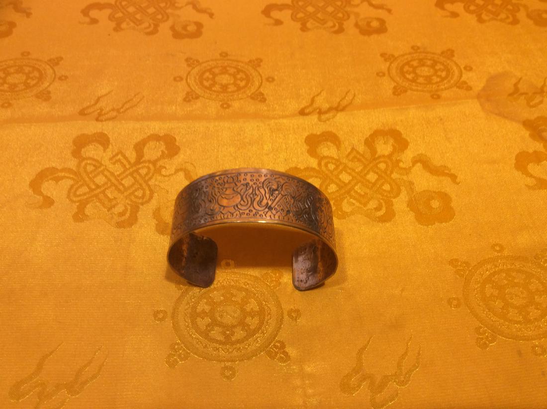 Solid Copper Bracelet.: Solid Copper Bracelet hand made in Nepal carved with Eight Tibetan Auspicious Symbols. 18" long, 1" wide and weighs 33 grams.