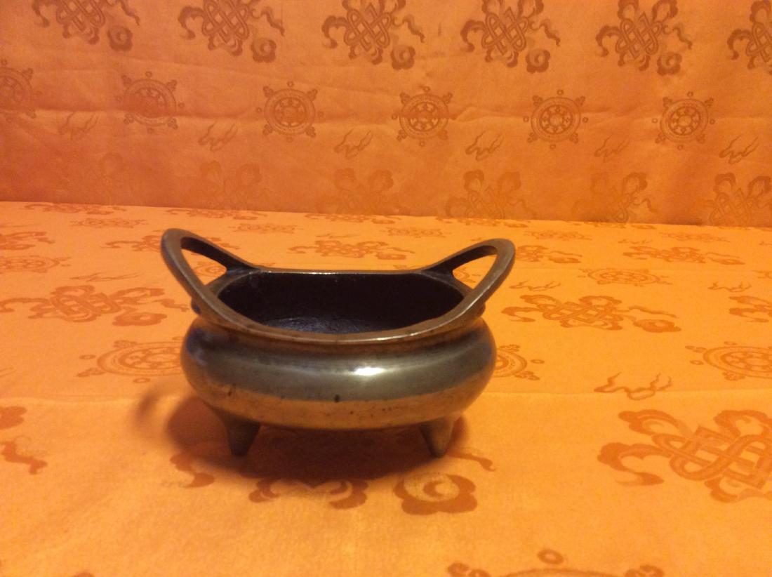 Small Incense Burner.: Small Vintage Incense Burner made with solid bronze, four sturdy feet and ytwo handles.There are some Chinese Characters at the bottom. Measures 3" tall, 4" wide and weighs 412 grams.