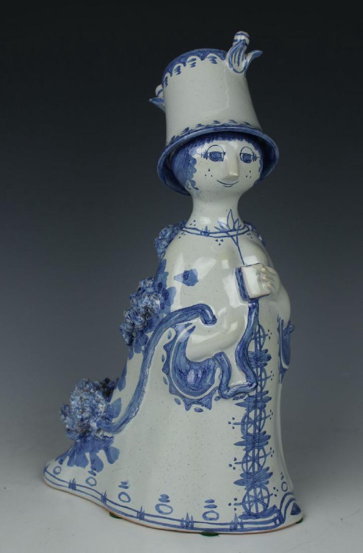 Bjorn Wiinblad figurine M12 "Aunt Ella with Book": MANUFACTURE: Nymolle (DENMARK) DESIGNED: Bjorn Wiinblad (1918-2006) NAME: Aunt Ella with Book SERIES: Aunt Ella YEAR: 1973 NUMBER: M12 CONDITION: Excellent. No chips, no cracks. NO BOX HEIGHT: 10 inch