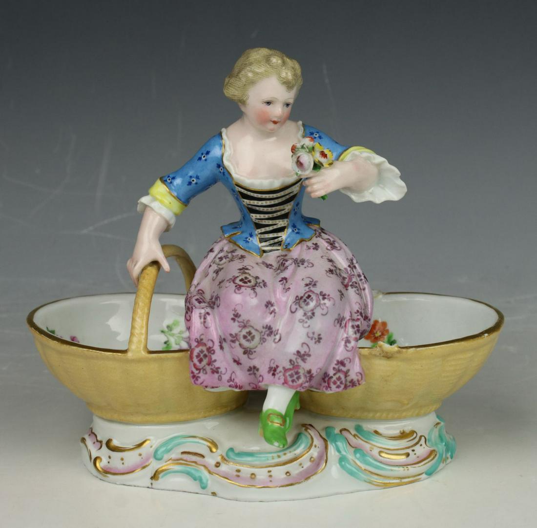Meissen Kaendler figurine 3024 "Girl with Baskets": MANUFACTURE: Meissen (GERMANY) SCULPTOR: Johann Joachim Kaendler ca. 1759 NAME: Girl with Baskets YEAR: 1850 - 1924 NUMBER: 3024 CONDITION: Missing one handle of basket. HEIGHT: 5 inch / 13 cm WIDTH: 