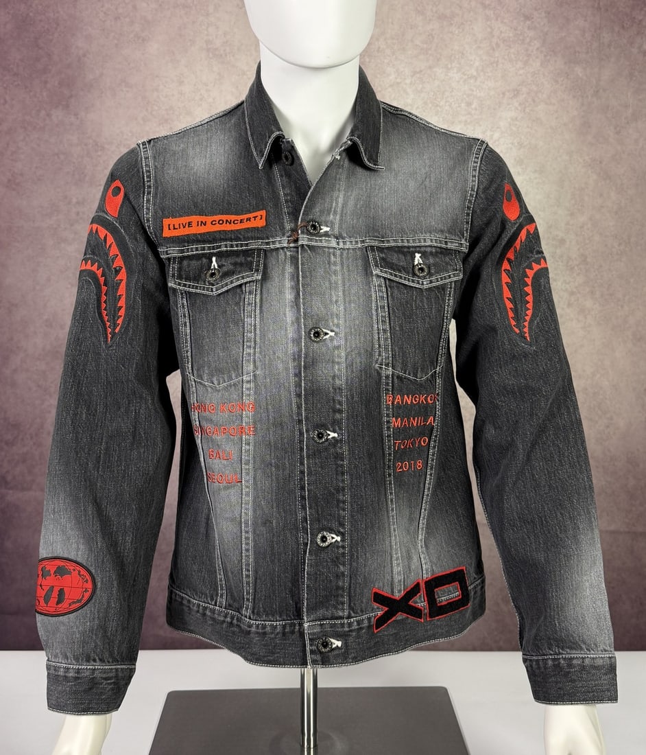 The Weeknd's Wardrobe - XO jacket: The Weeknd XO A Bathing Ape World Gone Mad 1993 to 2093 New Denim Jacket Till We Overdose XO Asia Live in Concert Hong Kong Singapore Bali Seoul Bangkok Manila Tokio 2018. XO is The Weeknd's own label