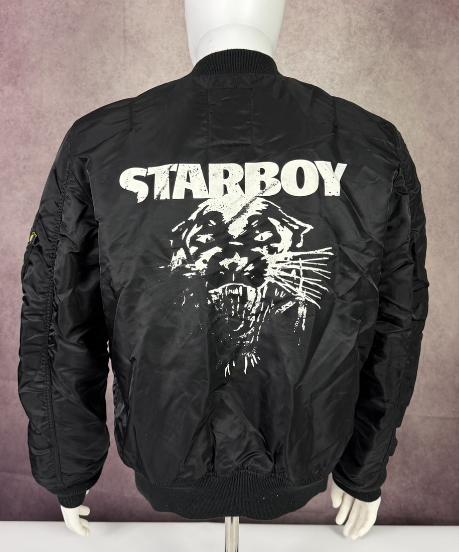 The Weeknd's Wardrobe - XO bomber jacket: XO Star Boy The Weeknd Black Bomber Satin Jacket. XO is The Weeknd's own label and lifestyle imprint, released through Republic Records. SIZE: L CONDITION: Pre-owned. The photographs are part of this 