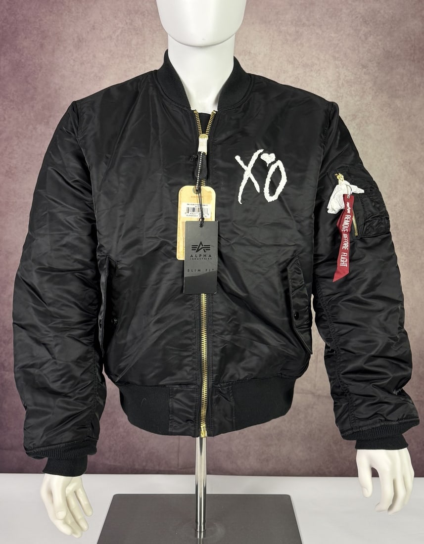 The Weeknd's Wardrobe - XO bomber jacket: The Weeknd x XO x Alpha Industries Bomber Jacket New. XO is The Weeknd's own label and lifestyle imprint, released through Republic Records. Noted by the consignor as new (unworn). SIZE: XL CONDITION: