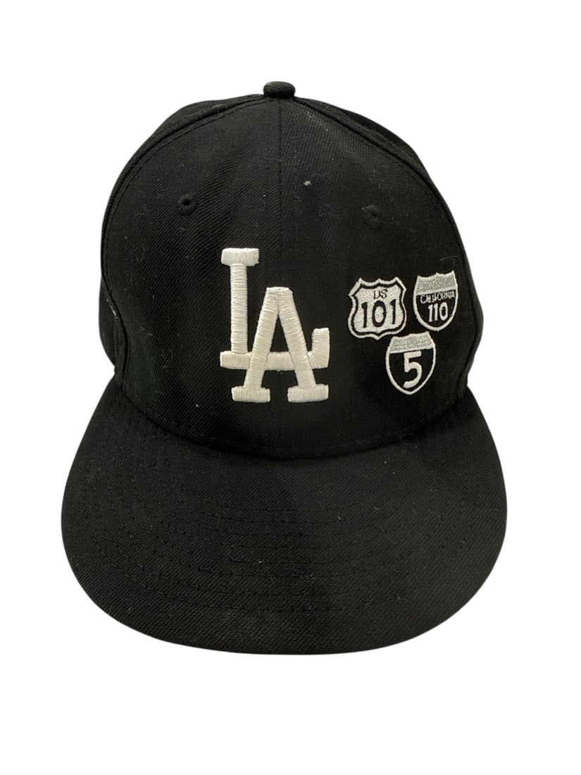 The Weeknd's Wardrobe - New Era cap: New Era Genuine Merchandise La Cap. Noted by the consignor as new (unworn). CONDITION: Pre-owned. The photographs are part of this description - please review them carefully to assess condition. PROVE