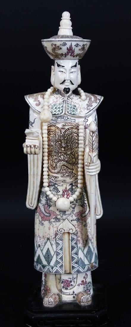 20th C. Chinese Carved Bone Emperor Sculpture: Early 20th century Chinese hand carved bone sculpture depicting a standing Emperor presenting sealed box in right hand with sword in sheath to left. Emperor is carved with hand painted dragon & lotus