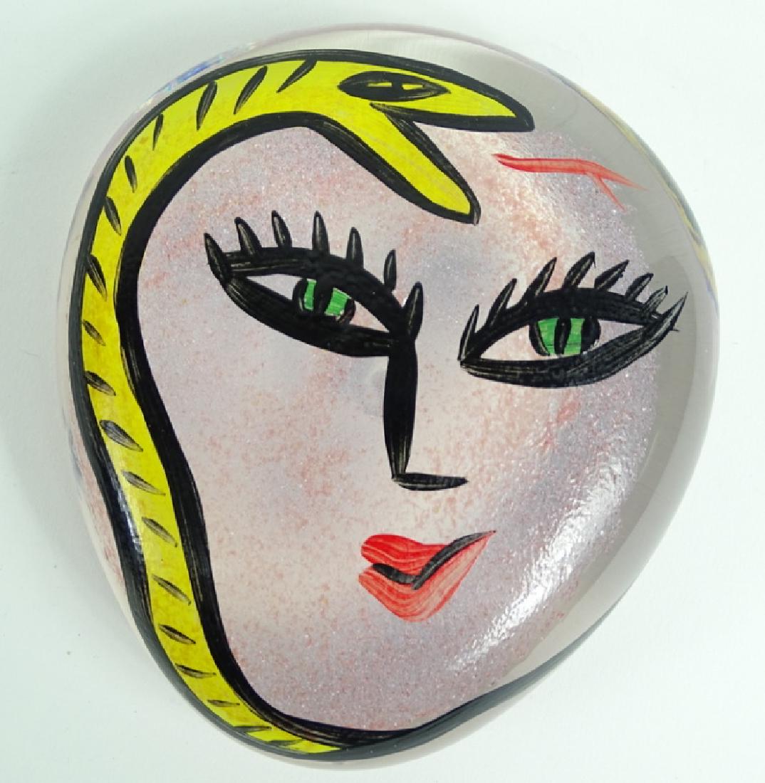 Kosta Boda Ulrica Hydman Vallien Glass Paperweight: Kosta Boda hand painted picasso style art glass paperweight by leading Swedish artist Ulrica Hydman Vallien. Artist signed to side. Signed & numbered in script to base. Measures: 5" L x 4-3/8" W 1-5/8