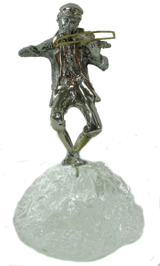 Yaacov Heller Silvered Fiddler Judaica Sculpture: Yaacov Heller (Israeli: B. 1941) original silvered sculpture of a fiddler atop an acrylic glass like rock (boulder) platform. Frank Meisler style sculpture. Incised signature to right leg. Measures: 1