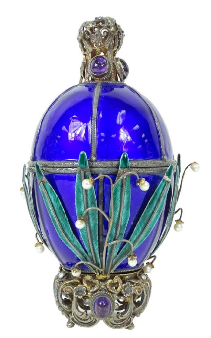 A Viennese Blue Enameled Silver Swan Egg: A Viennese Blue Enameled Silver Swan Egg. Leaf design, Pearls and amethyst. Minor loss on Enamel. Swan sculpture in the center in basket. Measures 6 1/2 inches high.