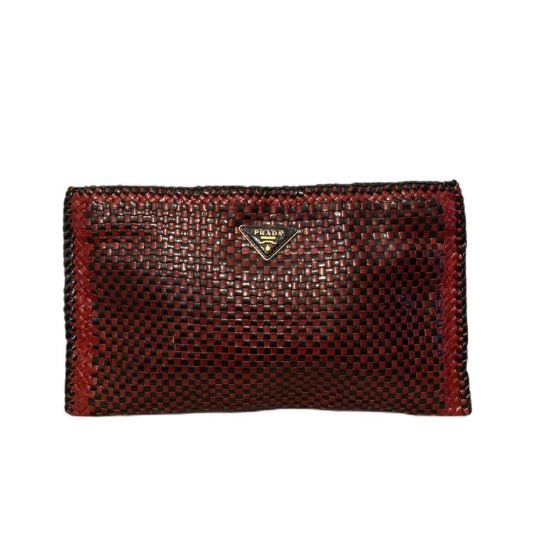 Prada Checkered Woven Leather Clutch: PRADA clutch comes in red and black woven leather with braided eave trim, gold tone logo plaque, zip closure, and suede interior. Measures: 8 inches high x 13.5 inches wide.