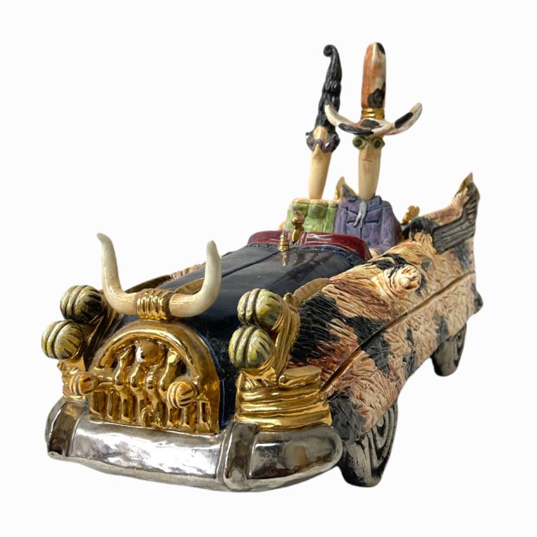Full Moon Clay Co. 24K Gold & Ceramic Automobile: Full Moon Clay Company ceramic automobile depicting a man and woman in a coupe with bullhorn hood ornament. Crafted with polychrome and 24k gold overlay. Limited edition 39/85. Measures approx. 11" he