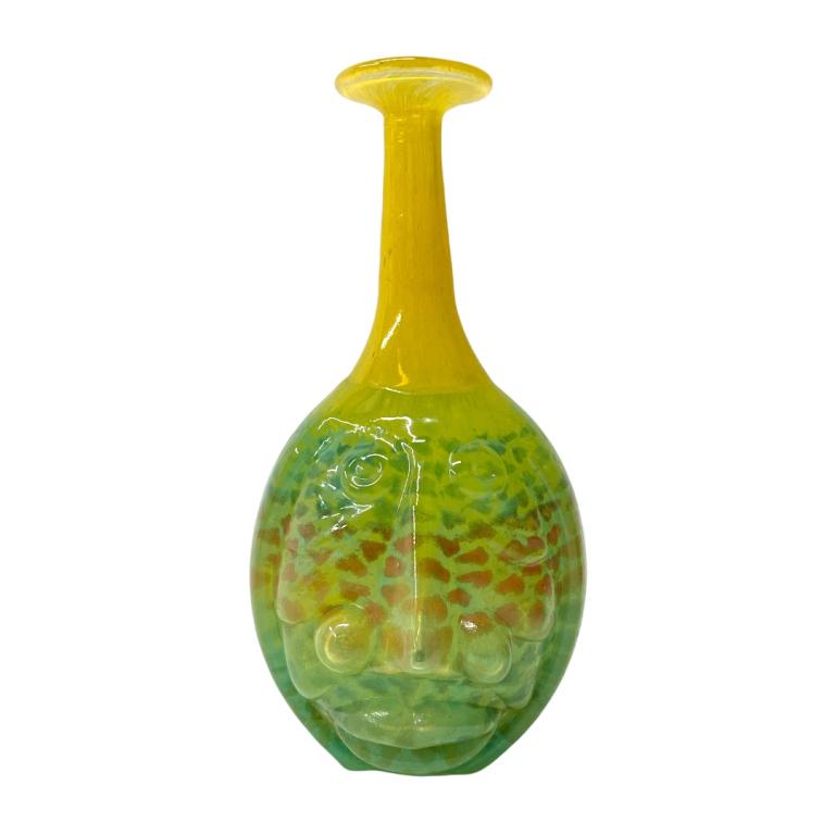 Kjell Engman Kosta Boda Glass "Rio Face Vase": Kjell Engman (SWEDISH, born 1946) for Kosta Boda studio art glass figural "Rio Face Vase" of green and yellow tones with flared rim. Dremel signed to bottom and retains factory label. Measures approx.