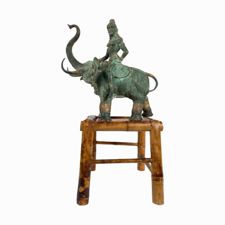 A vintage, possibly antique Thai Siam heavy bronze sculpture depicting Buddha seated atop an: A vintage, possibly antique Thai Siam heavy bronze sculpture depicting Buddha seated atop an elephant with trunk and tusks raised. Bronze has green patina throughout with gold gilt accenting. Includes