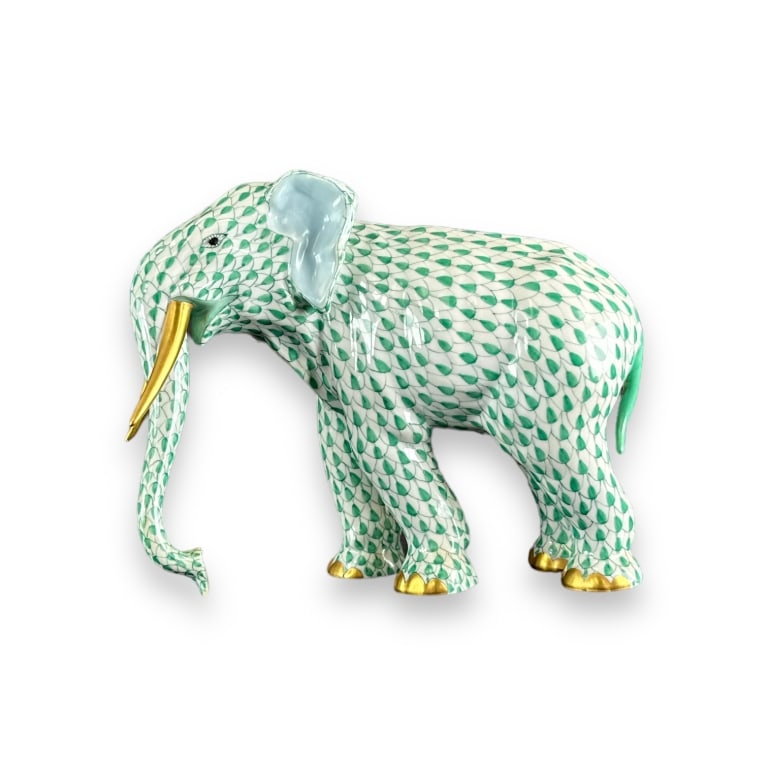 Herend Hungary hand painted green fishnet standing elephant sculpture completed with gilt tusk and: Herend Hungary hand painted green fishnet standing elephant sculpture completed with gilt tusk and toes. Blue stamp mark to bottom. Measures approx. 6" height x 7 1/4" width x 4" depth. Appears in ove